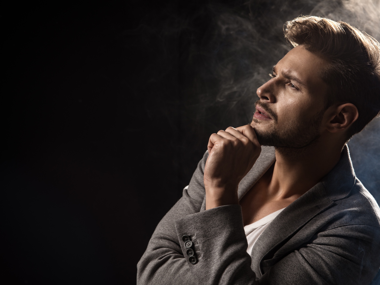 Задумчивый взгляд мужчины на черном фоне 