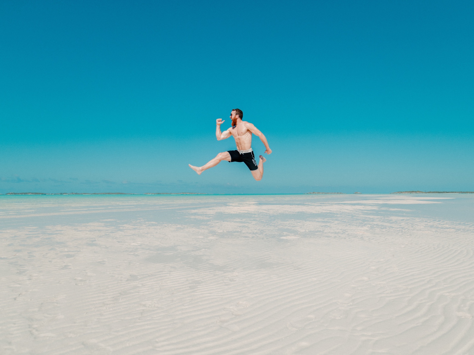 Довольный мужчина прыгает в воде на голубом фоне 