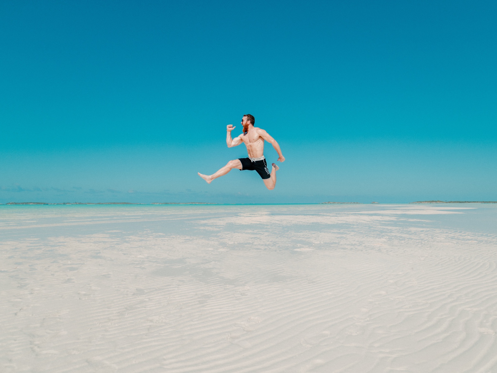 Довольный мужчина прыгает в воде на голубом фоне 