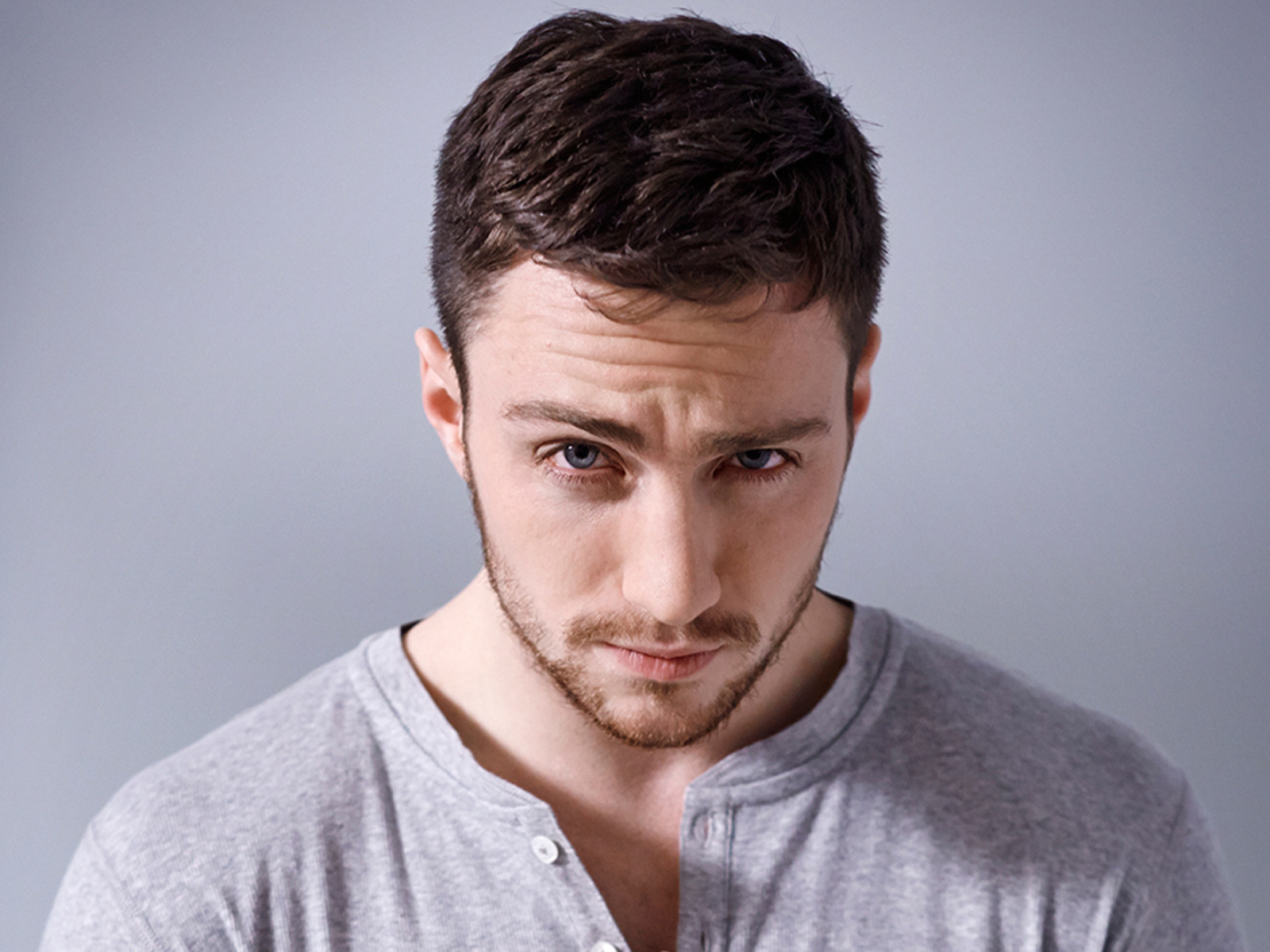 Молодой голубоглазый мужчина на сером фоне
