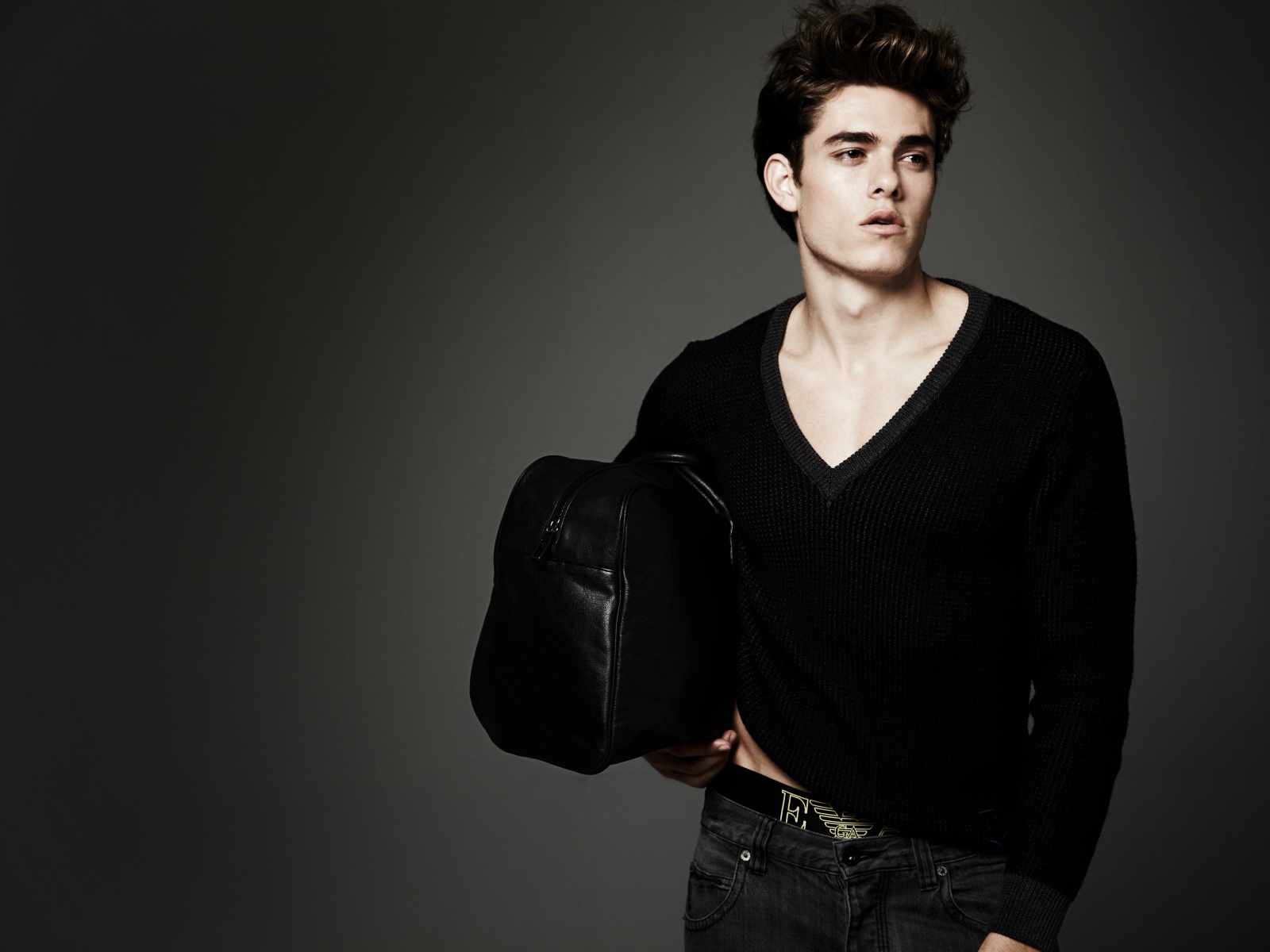 Молодой мужчина с черной сумкой в руке 