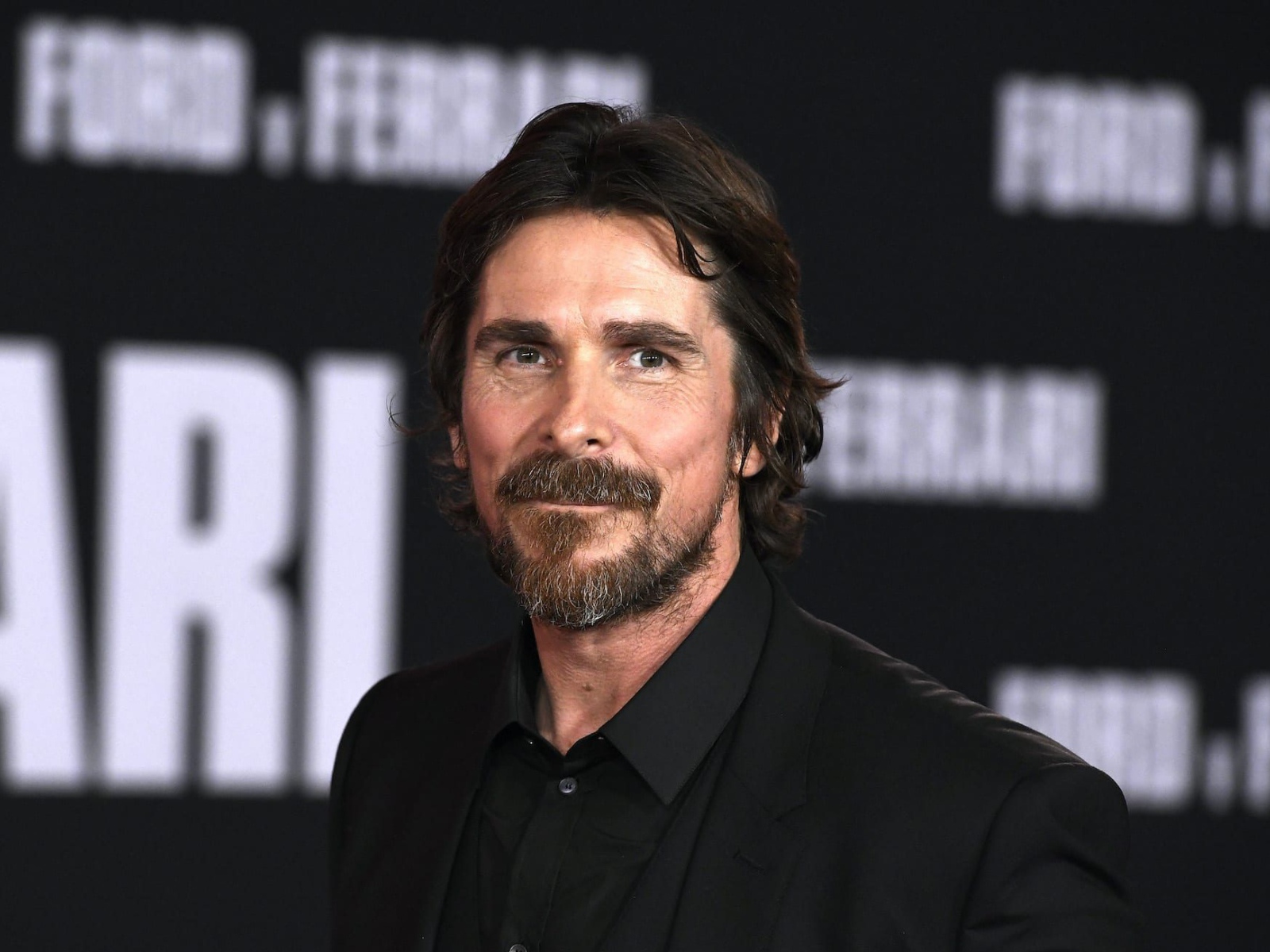 Актер Кристиан Бэйл в черном костюме