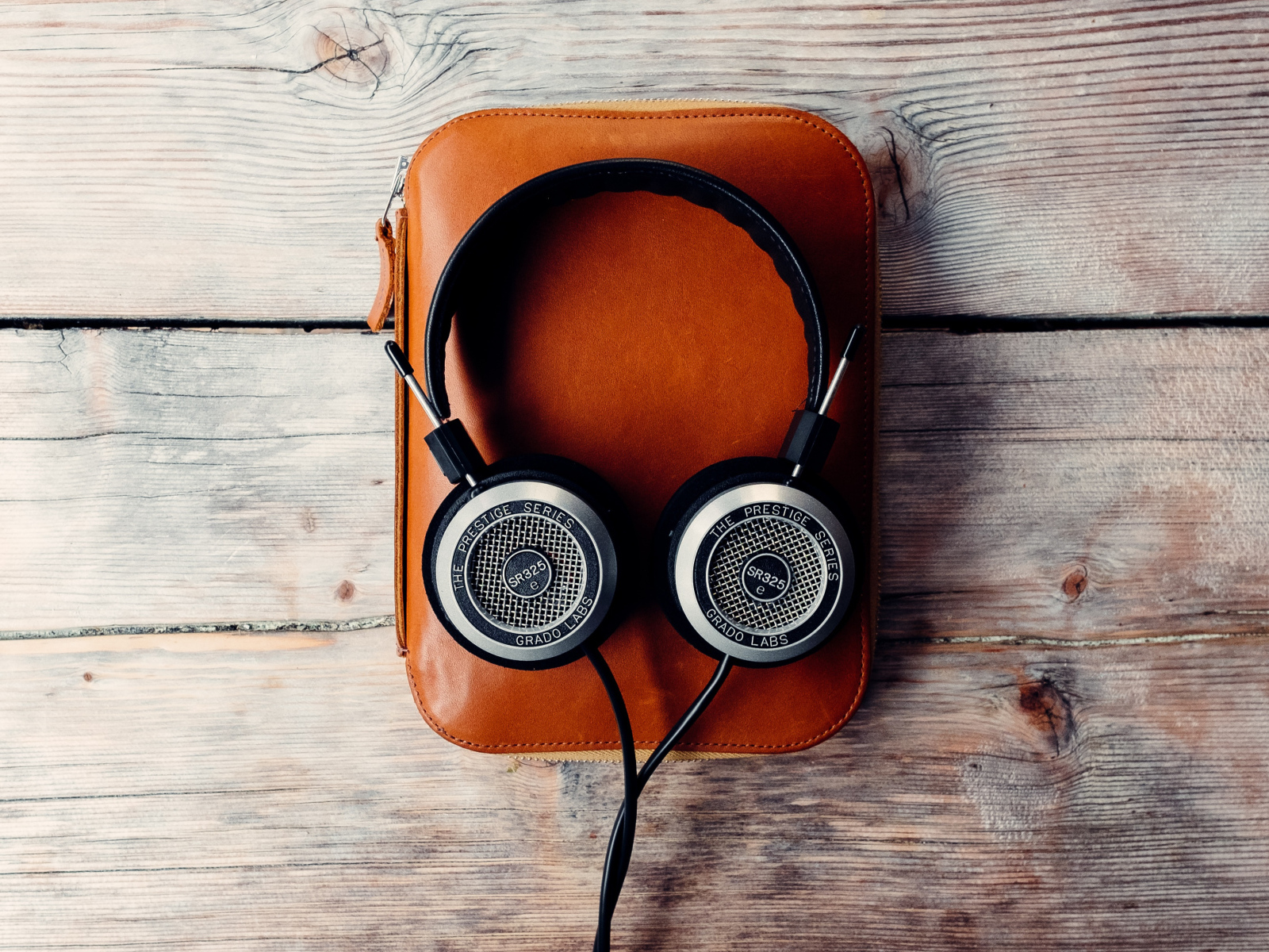 Наушники и плеер в чехле на деревянном столе