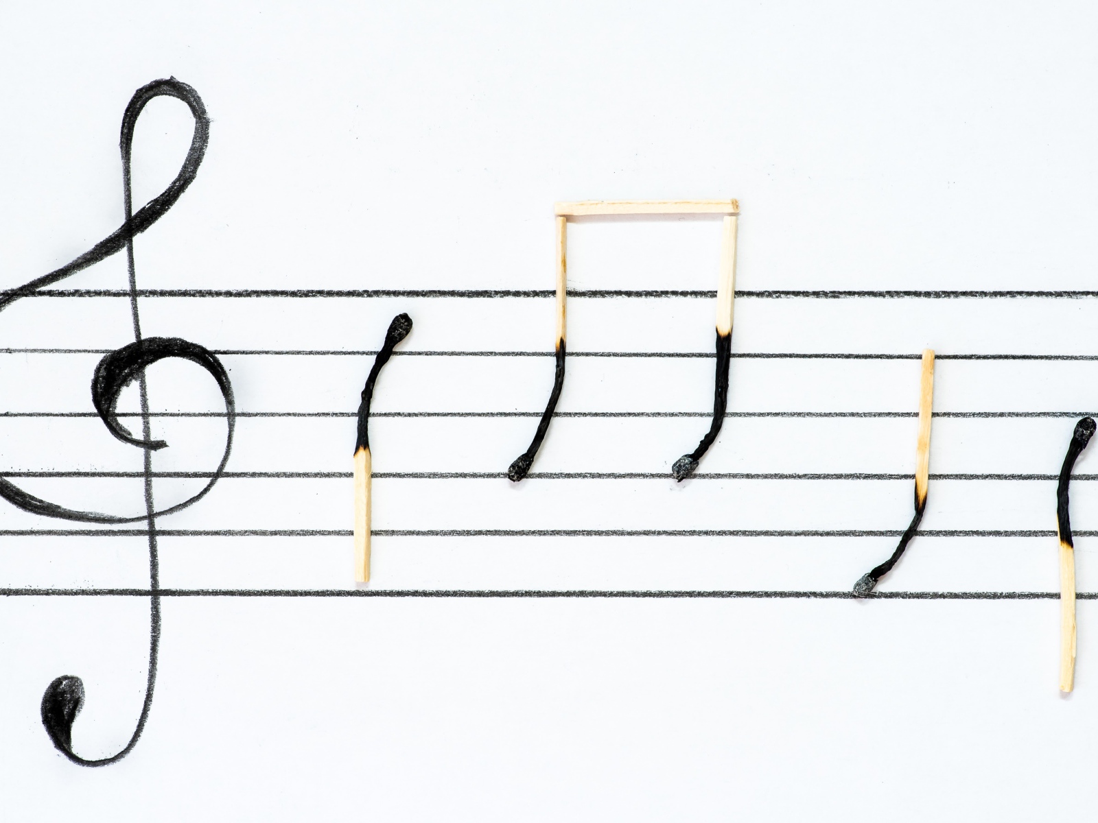 Ноты на белом фоне из сожженных спичек