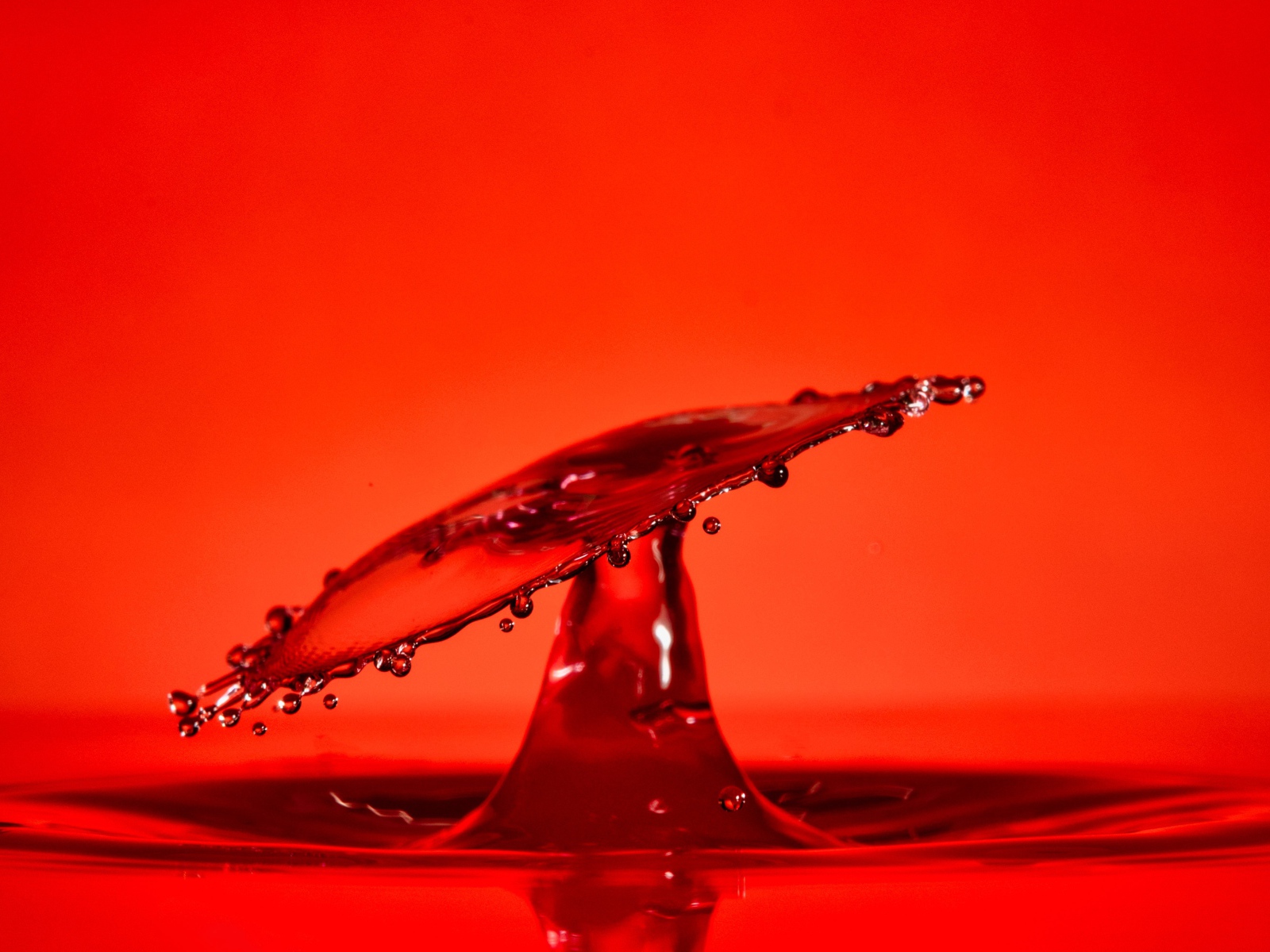 Брызги воды на красном фоне
