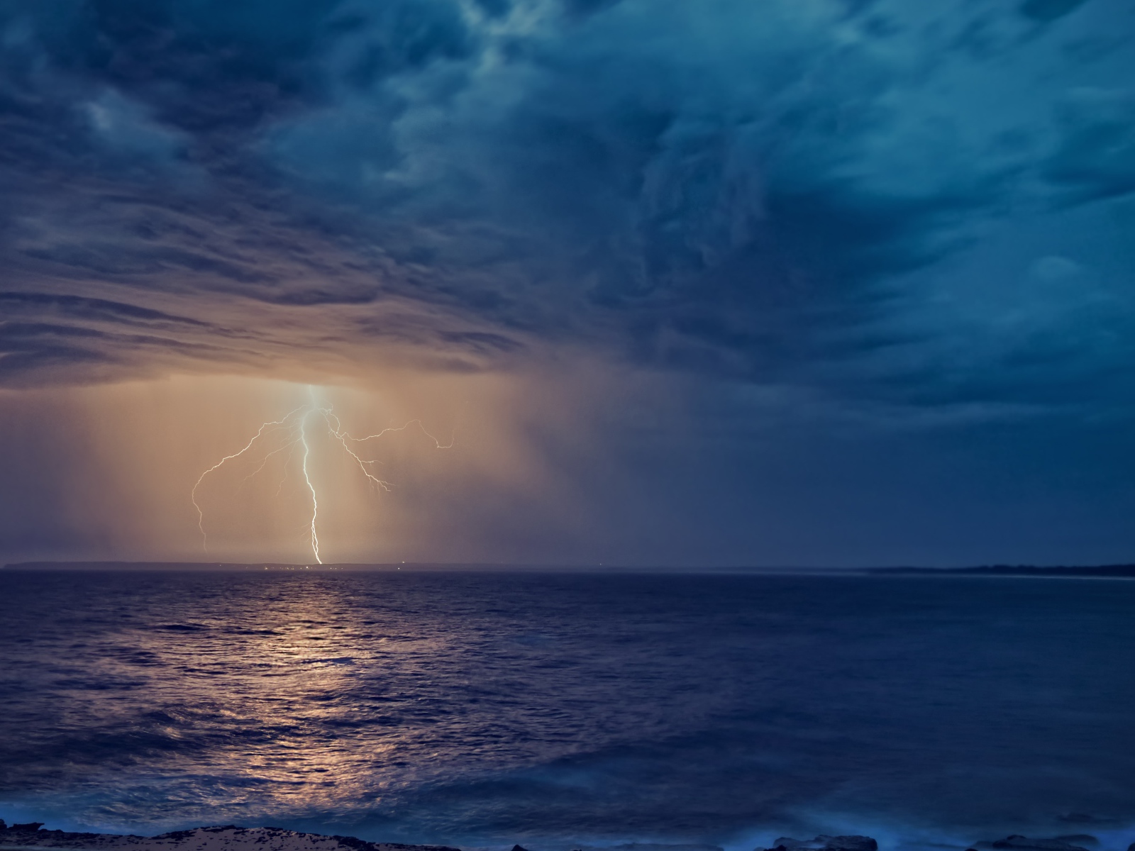Белая молния рассекает небо в море 