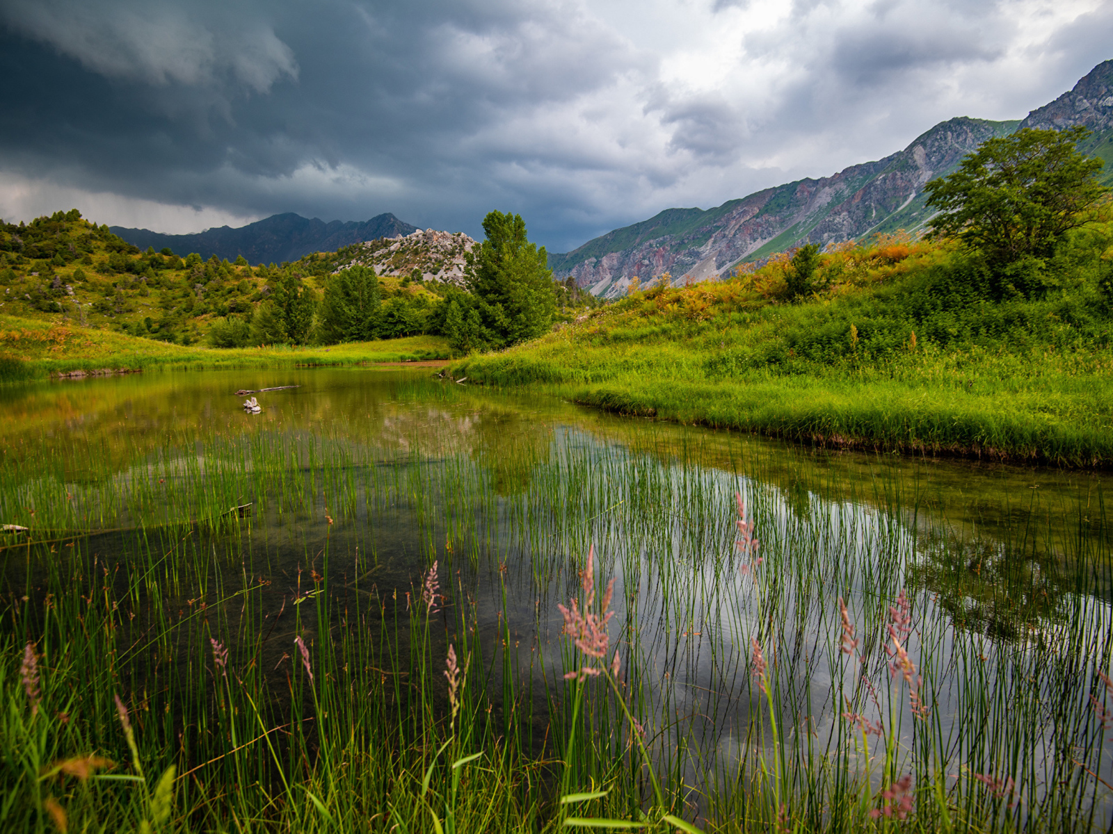 Грозовые облака над рекой в горах 