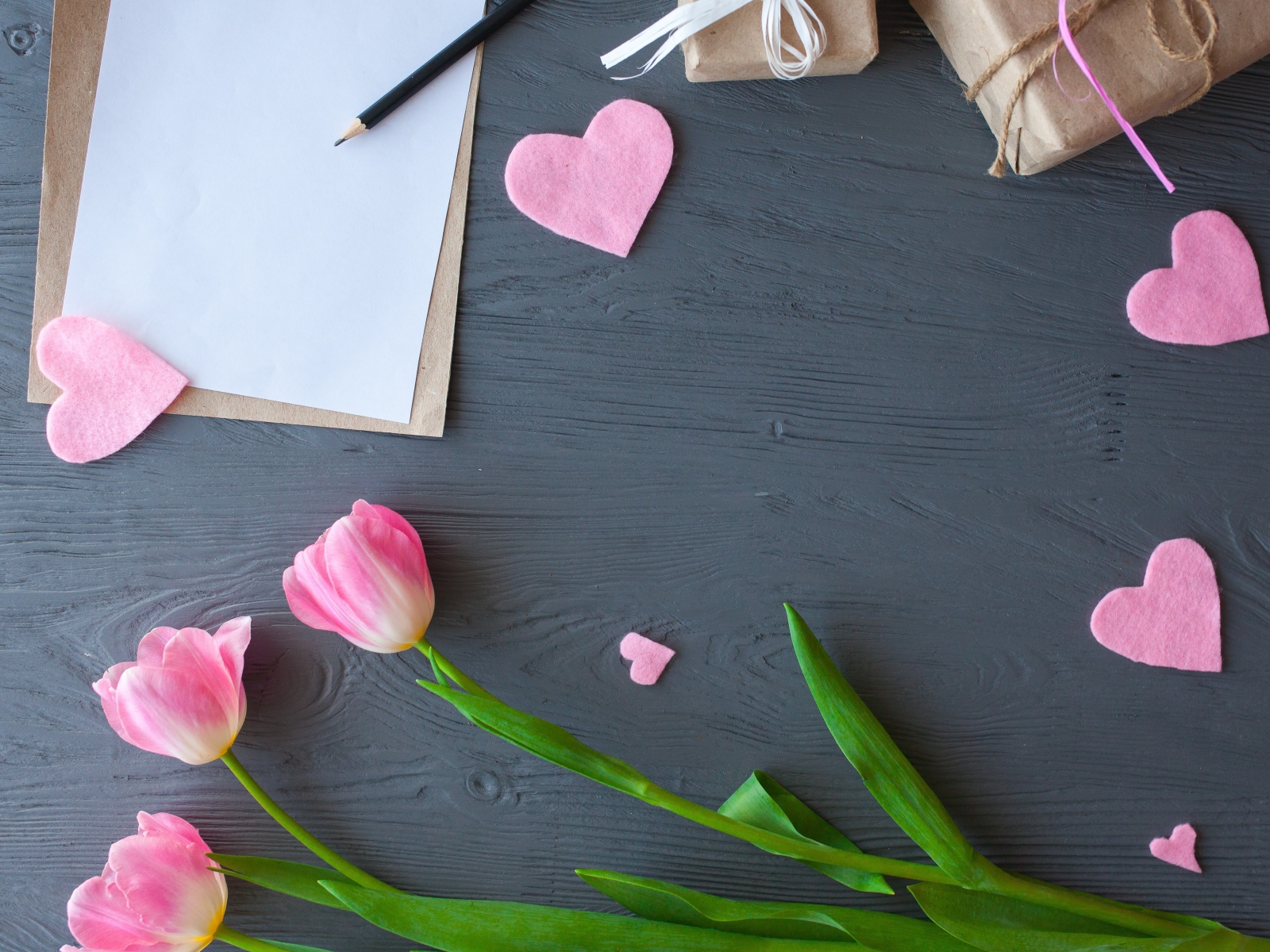 Тюльпаны, лист бумаги и сердечки на сером столе