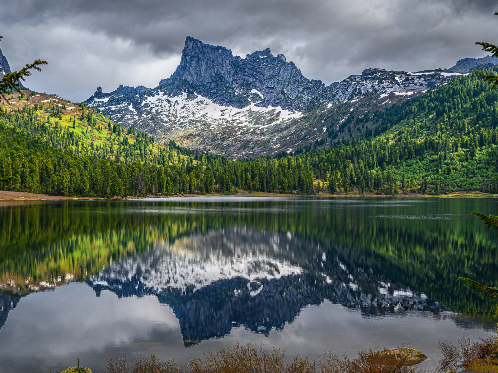 Красивая гора под грозовым небом отражается в озере 