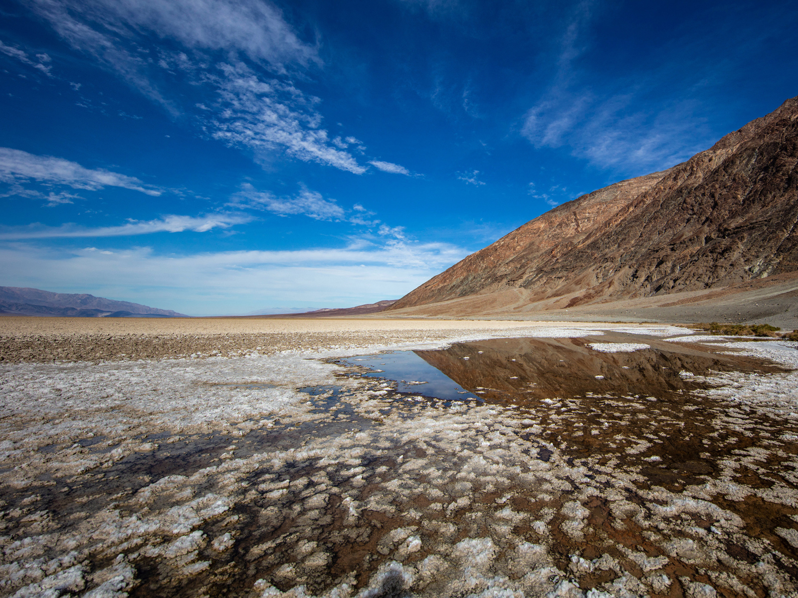 Соленая земля у горы под голубым небом