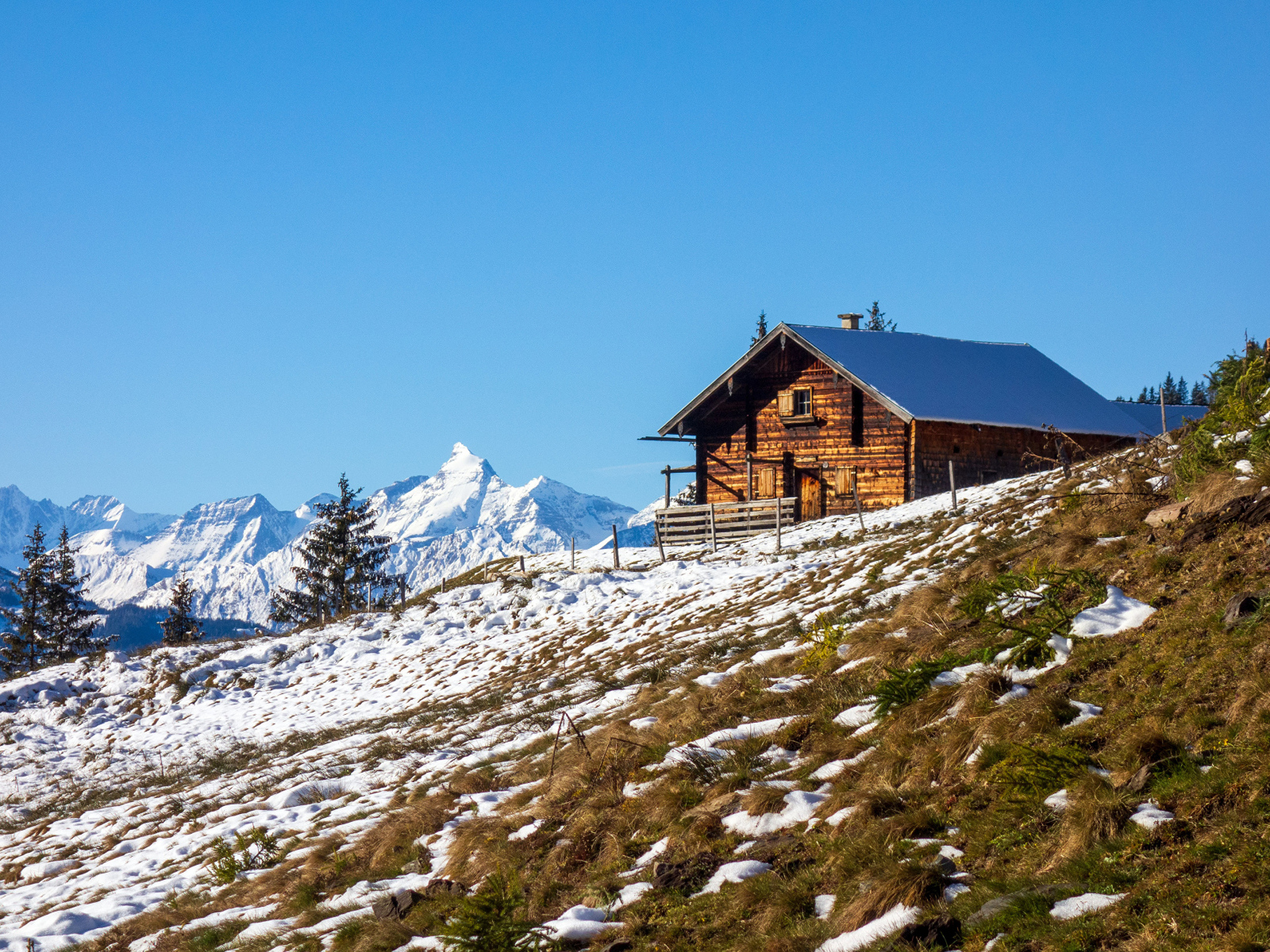 Деревянный дом на заснеженном склоне Альп