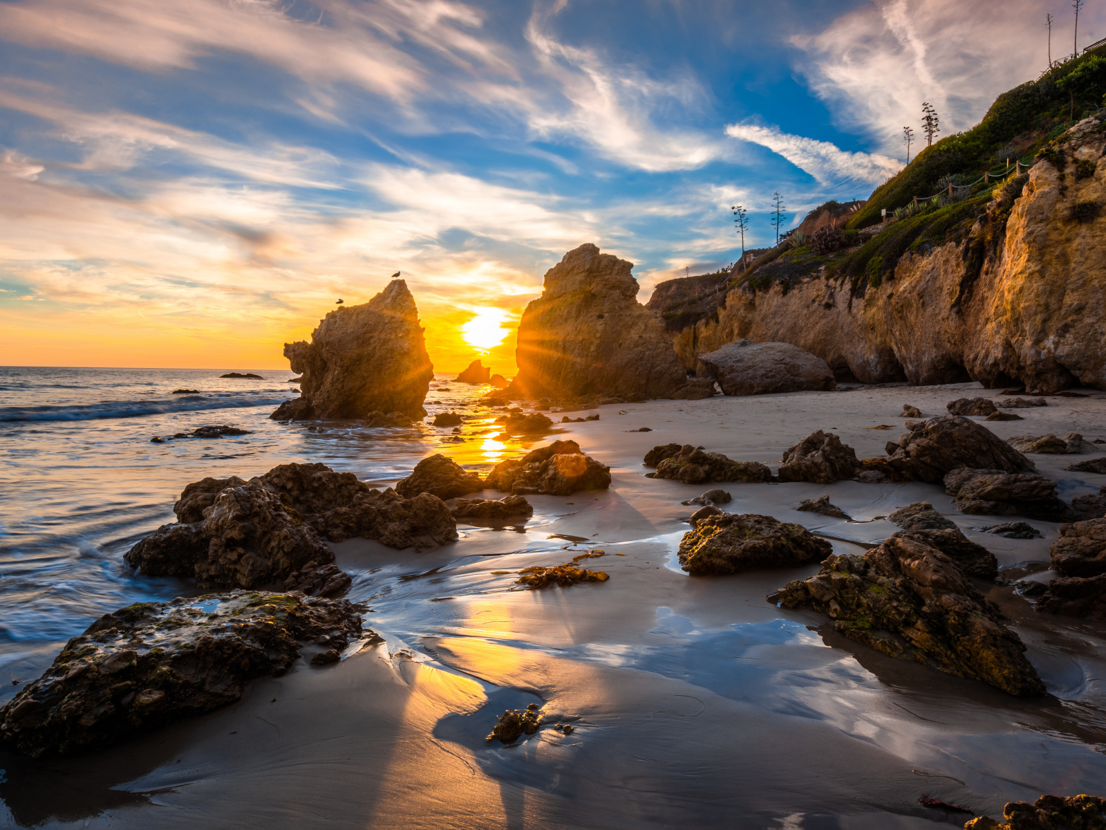 Яркий рассвет летнего солнца над скалами и океана