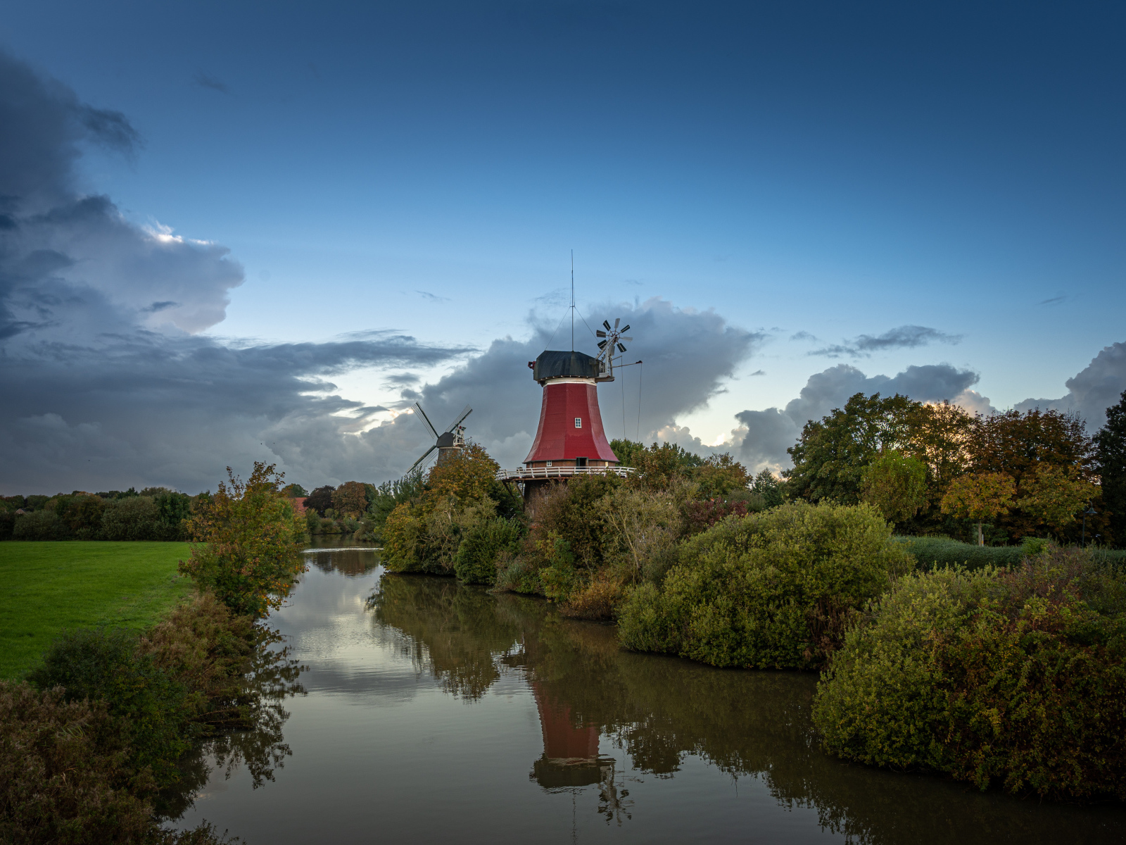 Мельница на берегу реки под красивым небом в сумерках