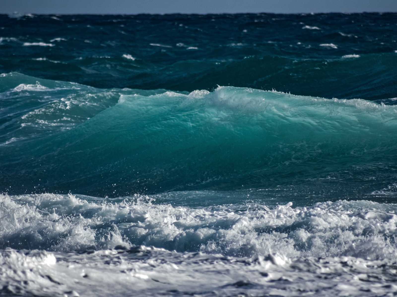 Волны с белой пеной поднимаются в море