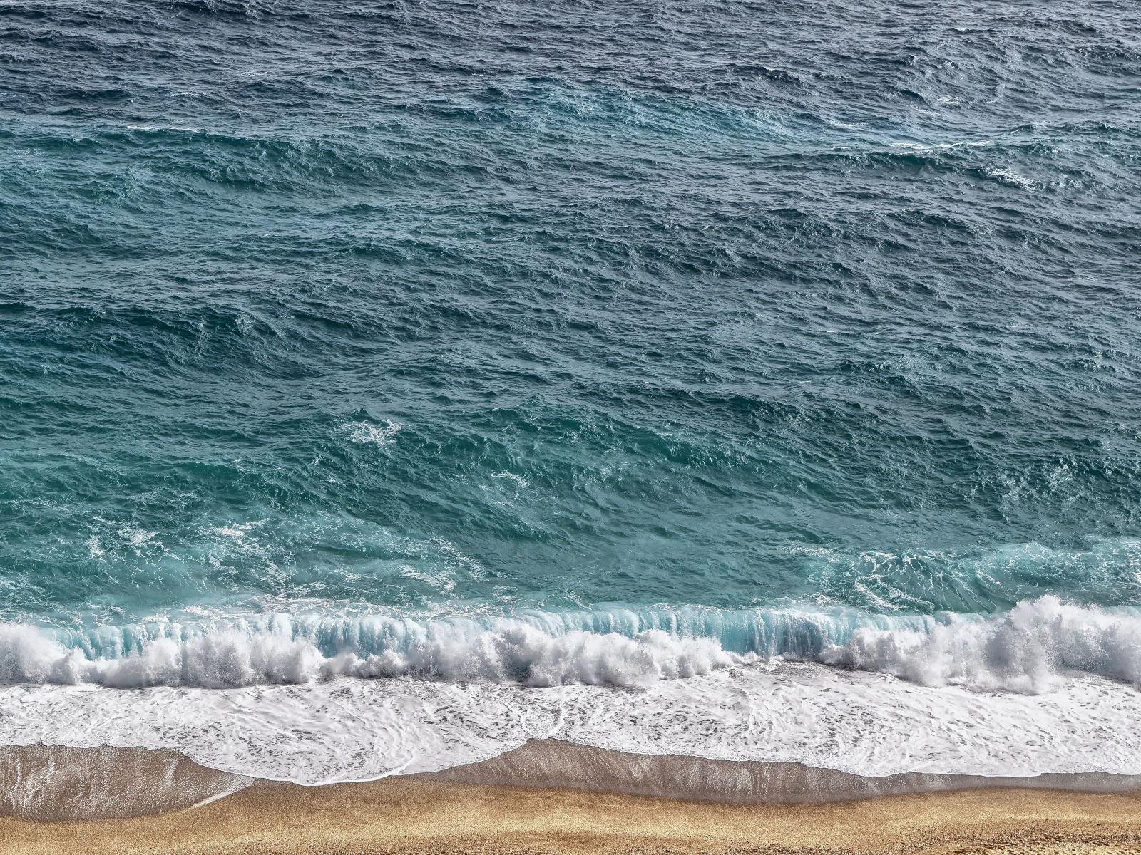 Белая пена от голубой морской воды на песке 