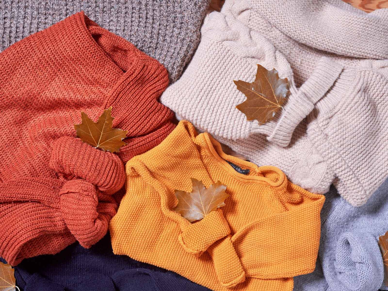 Warm knitted clothes with autumn leaves