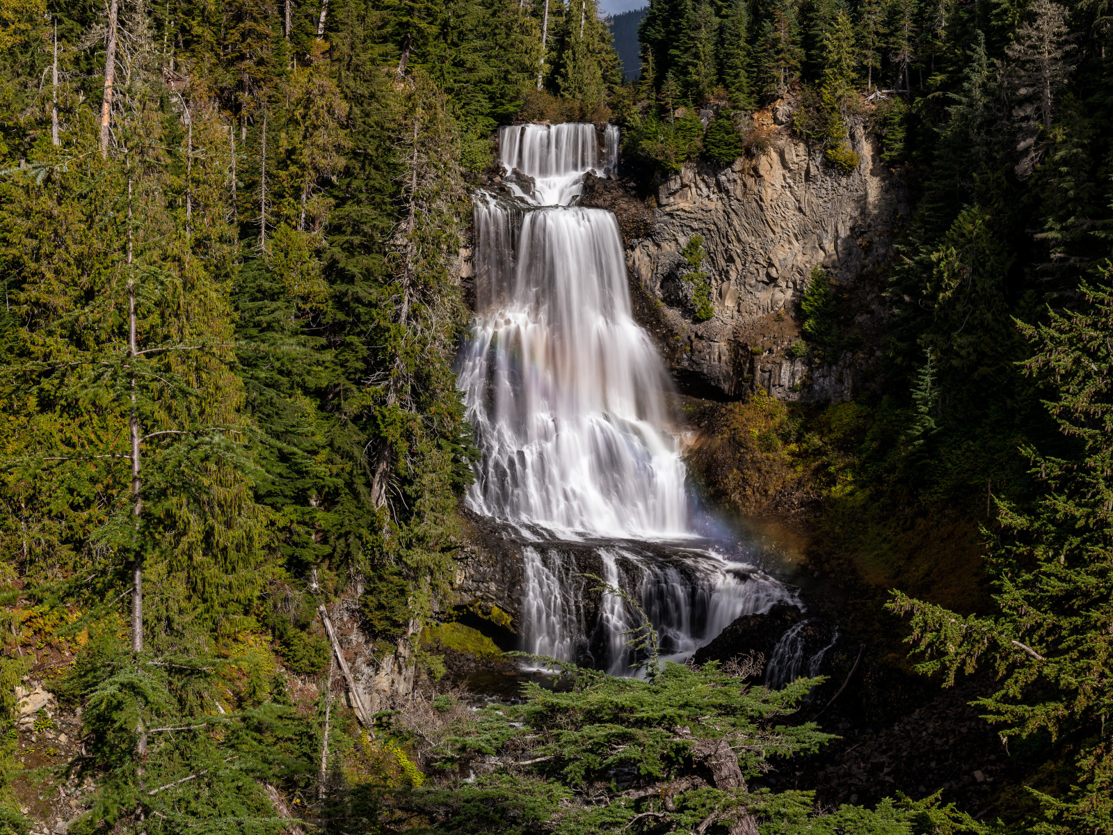 Большой водопад Александр стекает по скале в лесу 