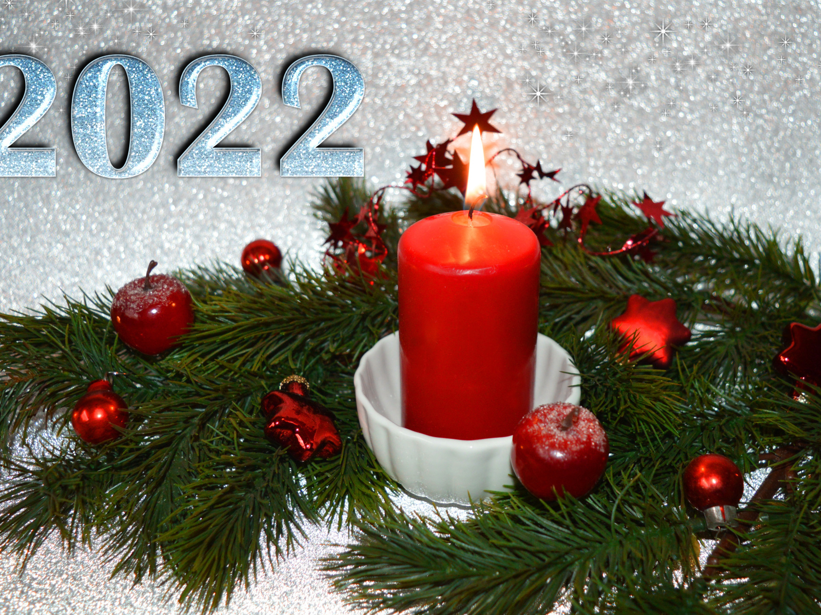 Свеча и еловая ветка с украшениями на новый год 2022