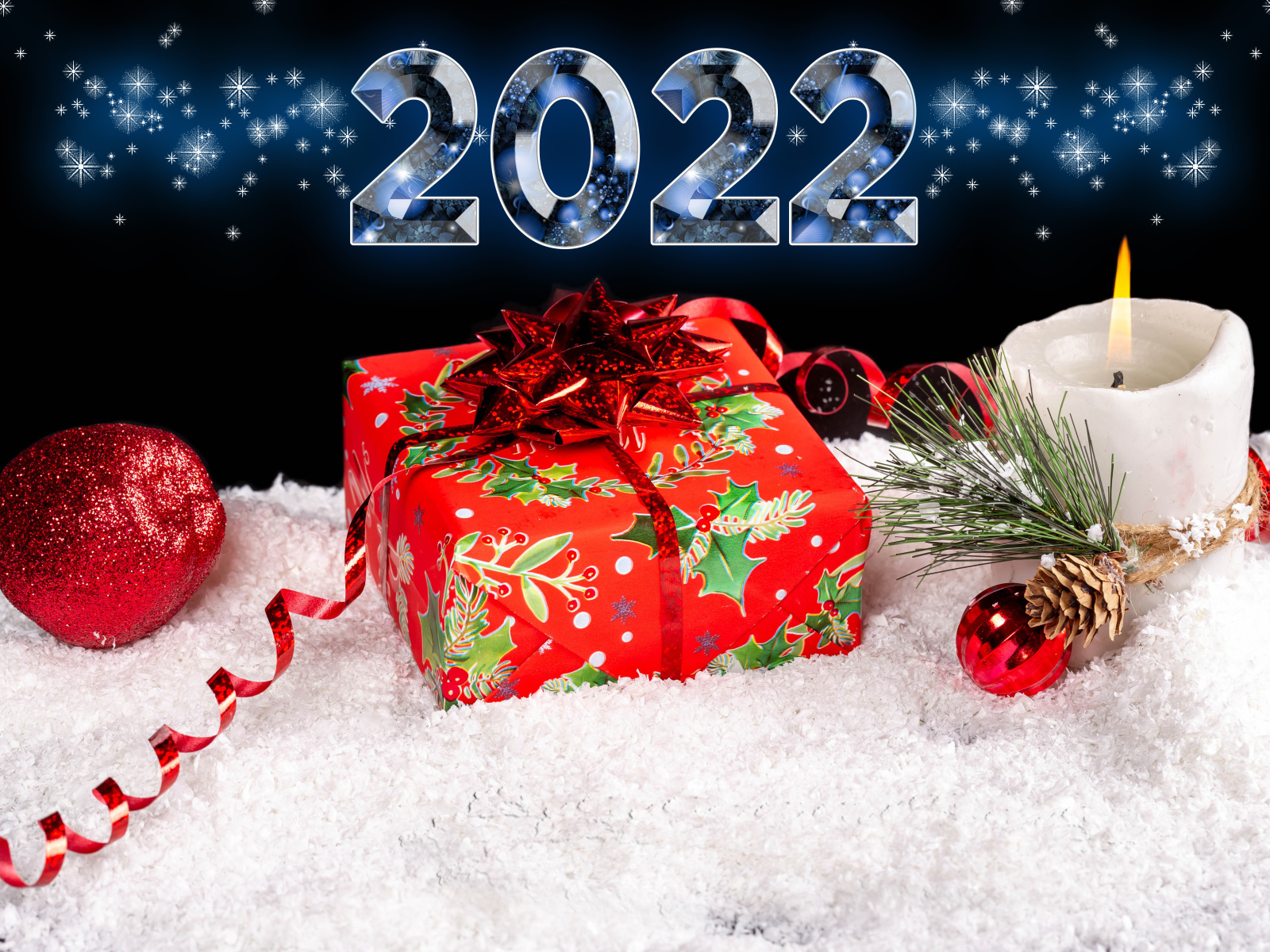 Подарок и свеча на снегу на новый год 2022 