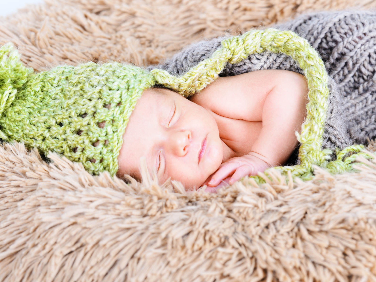 Красивый спящий грудной ребенок в вязаном костюме 