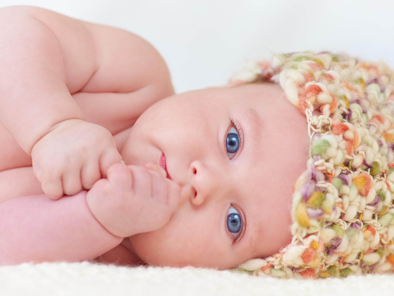 Голубоглазый грудной ребенок в шапке 