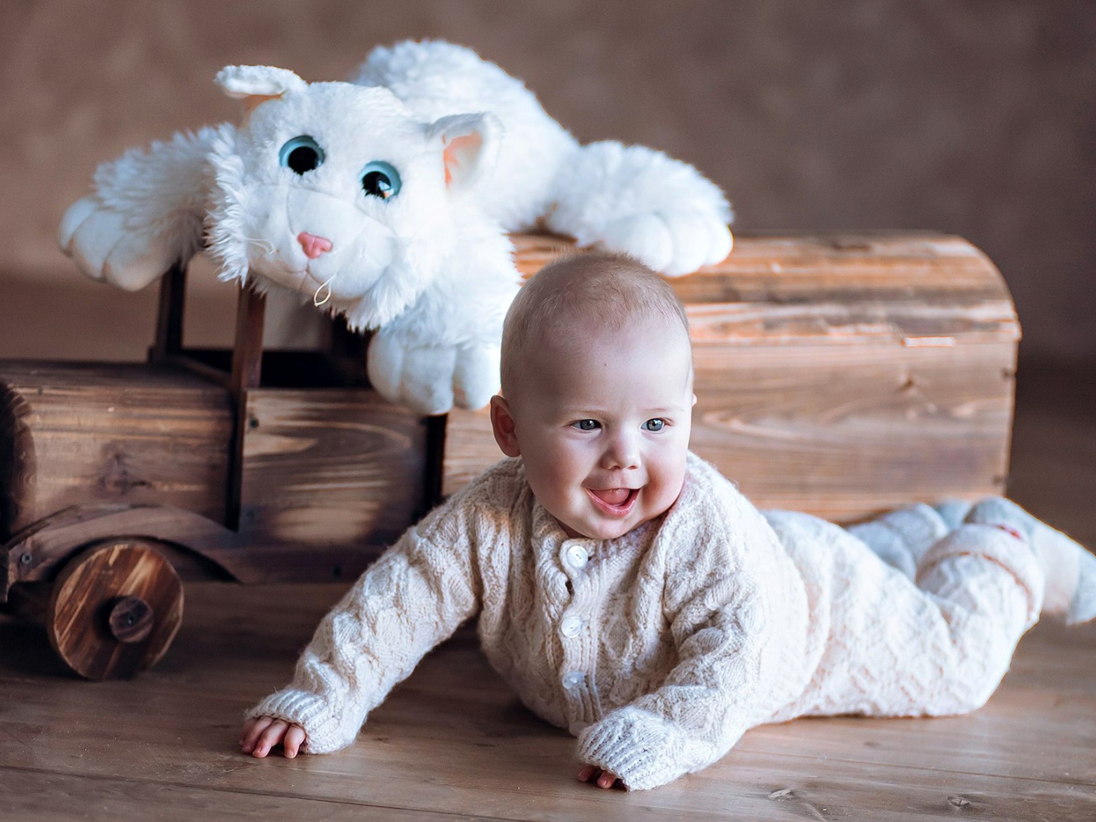 Веселый грудной ребенок с игрушечной машинкой 