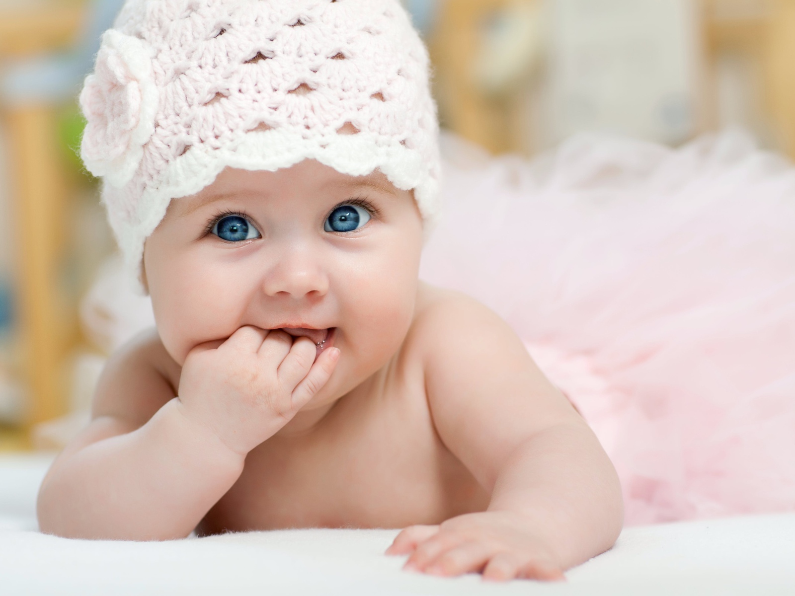 Милая голубоглазая малышка в розовой шапке 