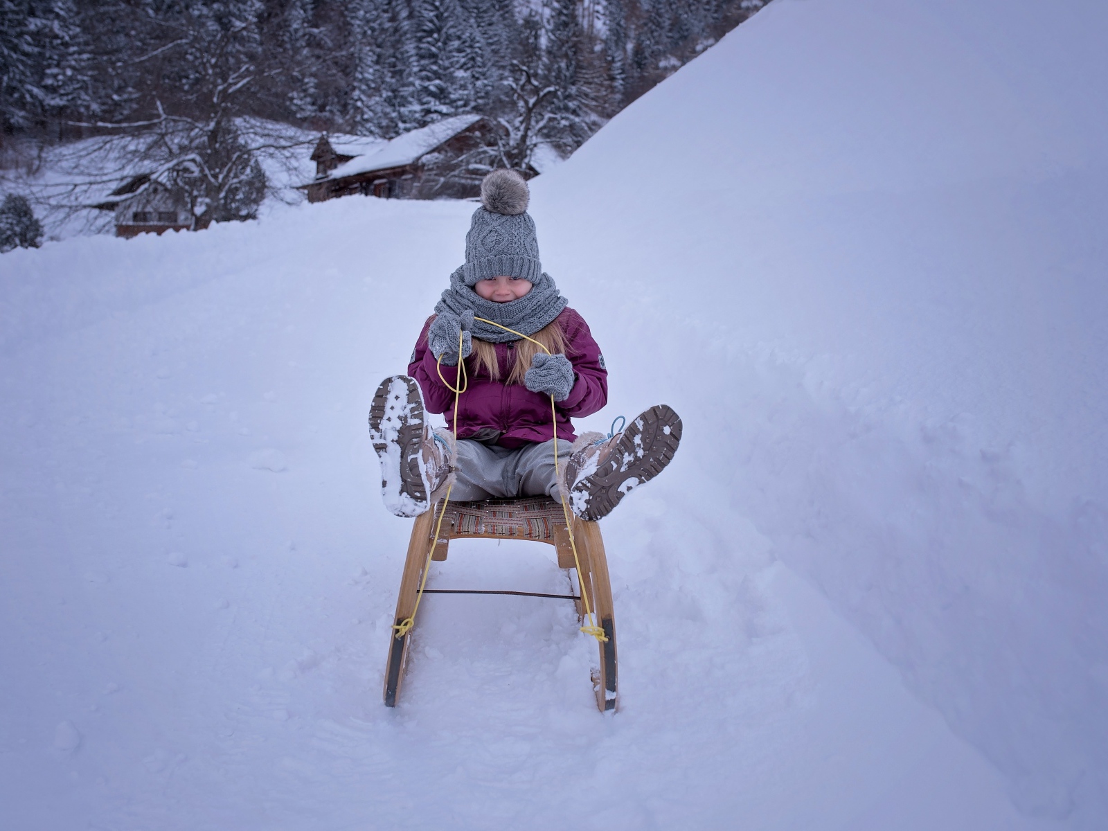 Девочка едет на санках с горки