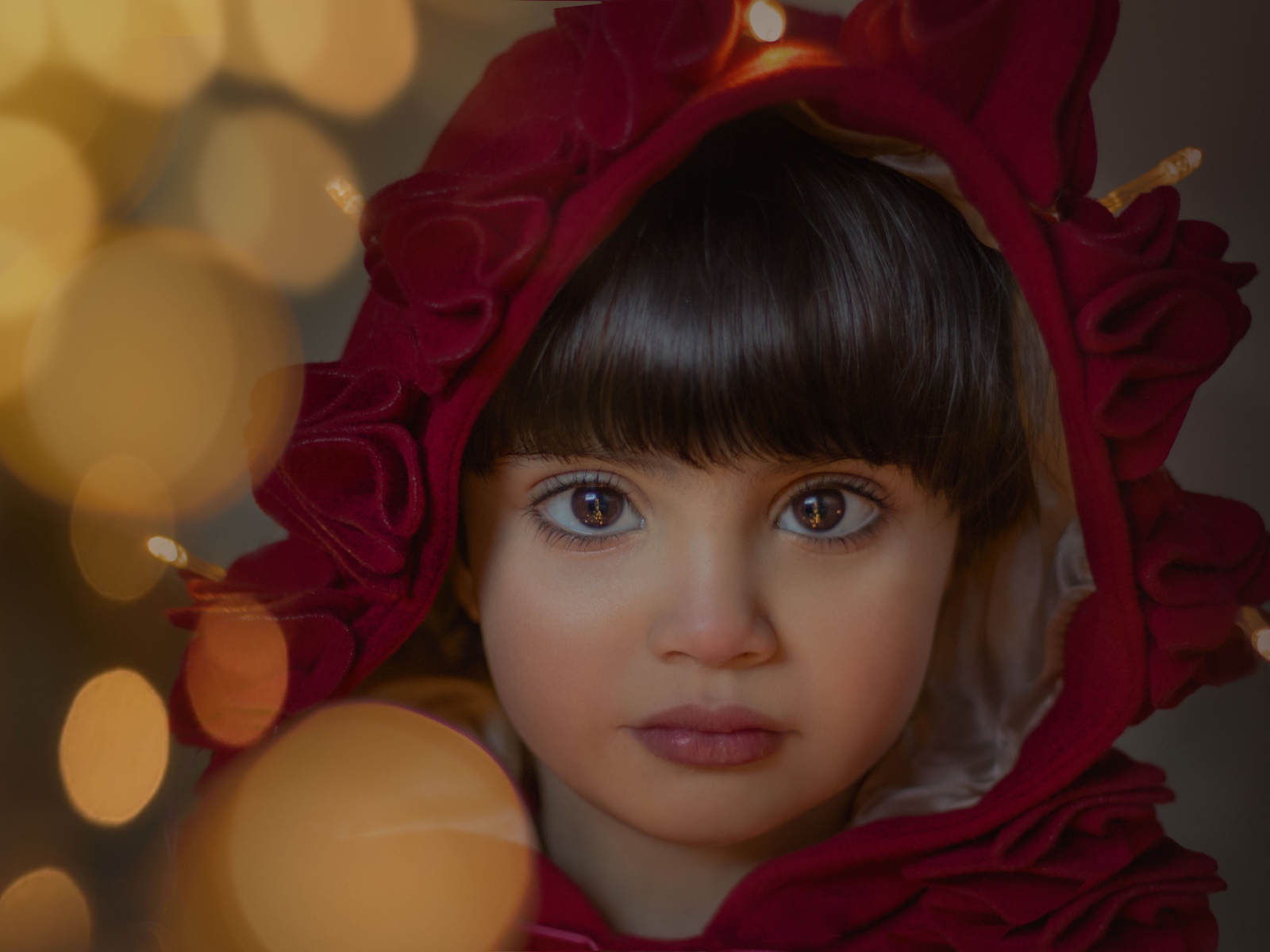 Девочка с большими карими глазами в красном капюшоне