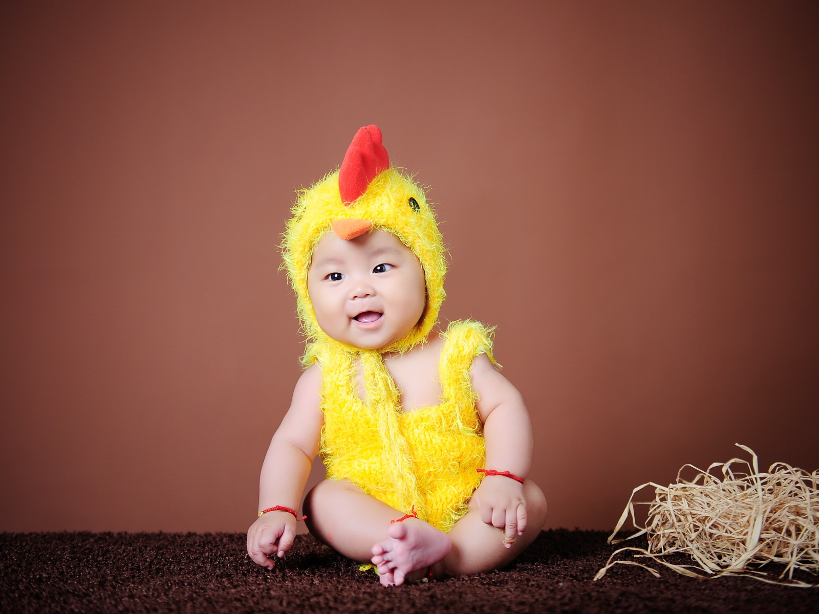 Маленький мальчик азиат в костюме цыпленка
