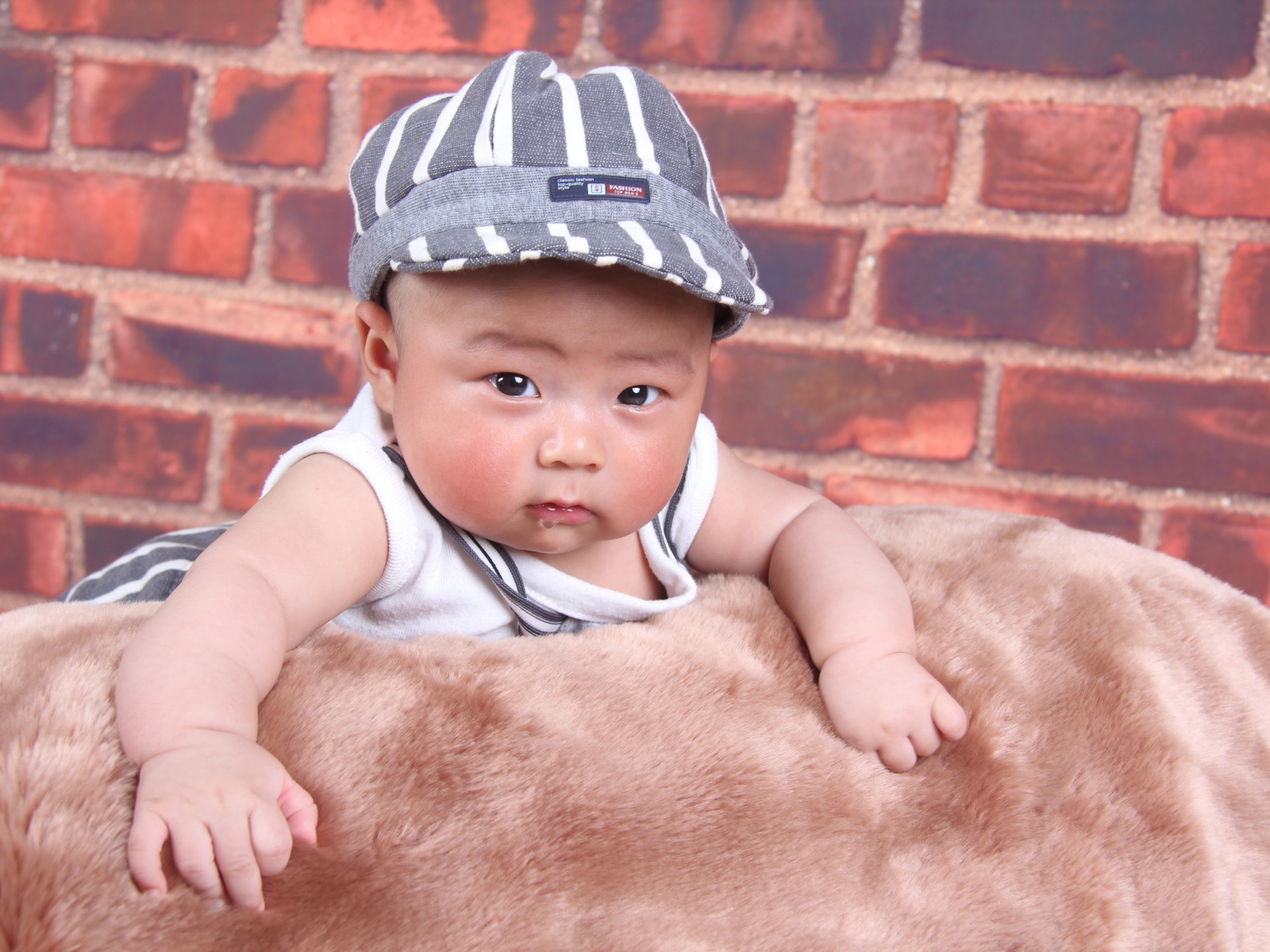 Маленький азиатский ребенок на фоне стены