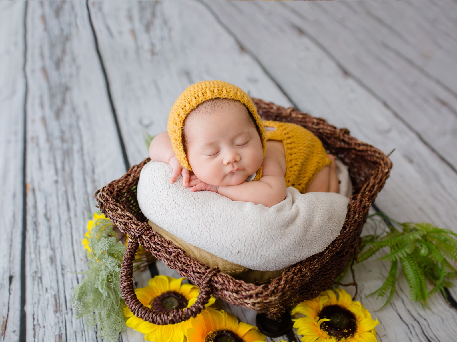 Маленький ребенок спит в плетеной корзине 