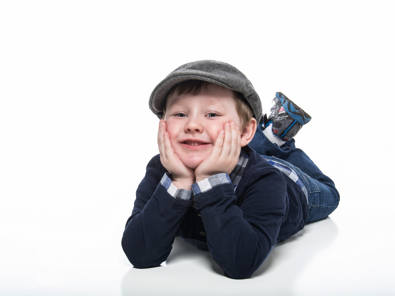 Маленький милый мальчик в кепке на белом фоне