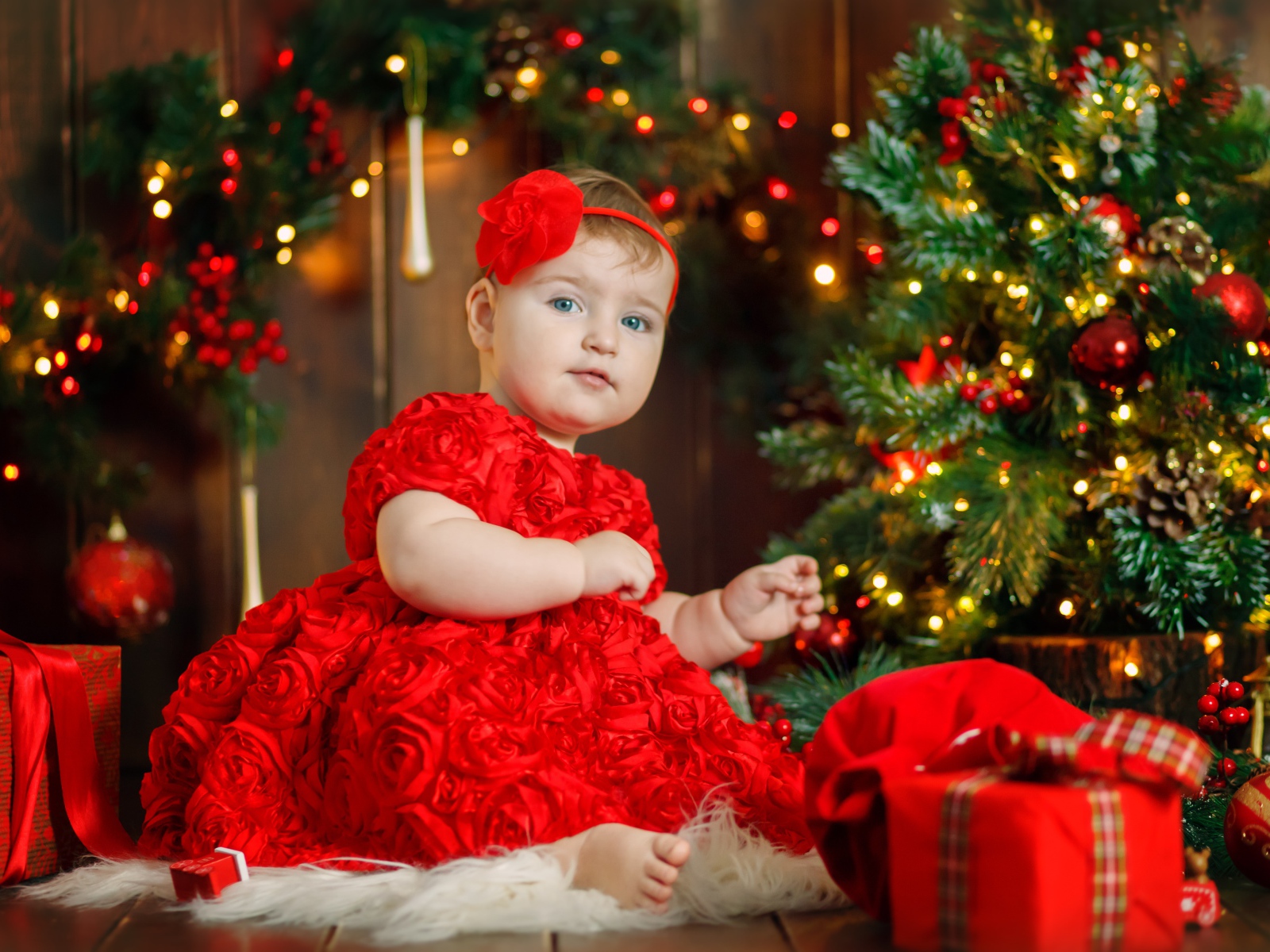 Маленькая девочка в красивом платье у наряженной ели 