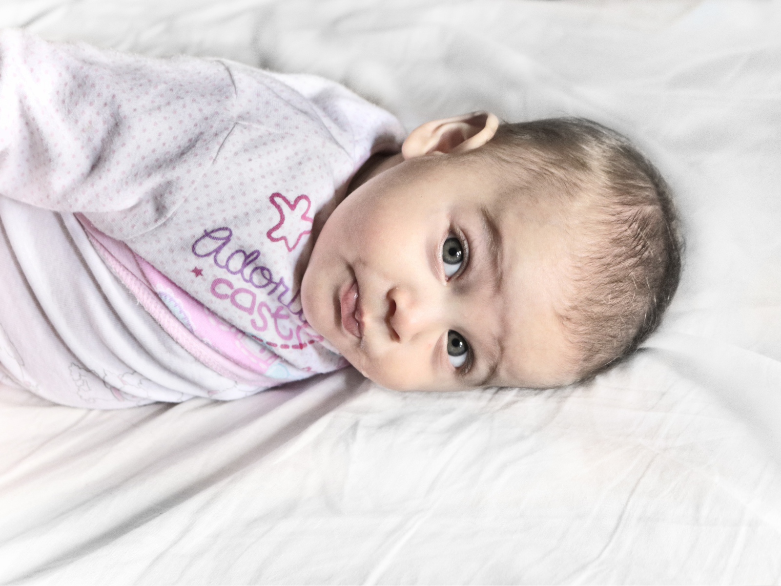 Маленький новорожденный ребенок лежит на кровати 