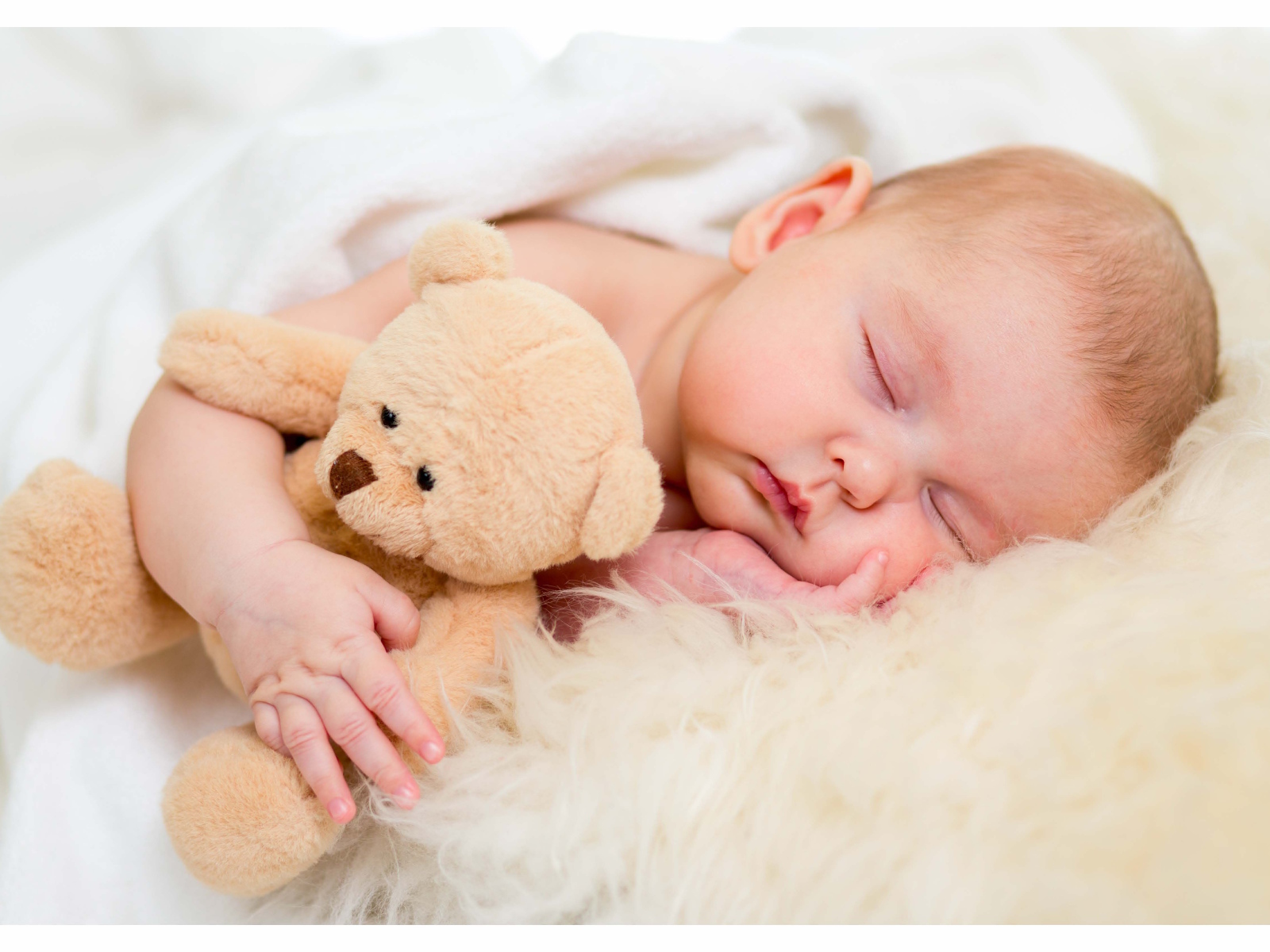 Новорожденный ребенок спит с игрушечным медведем