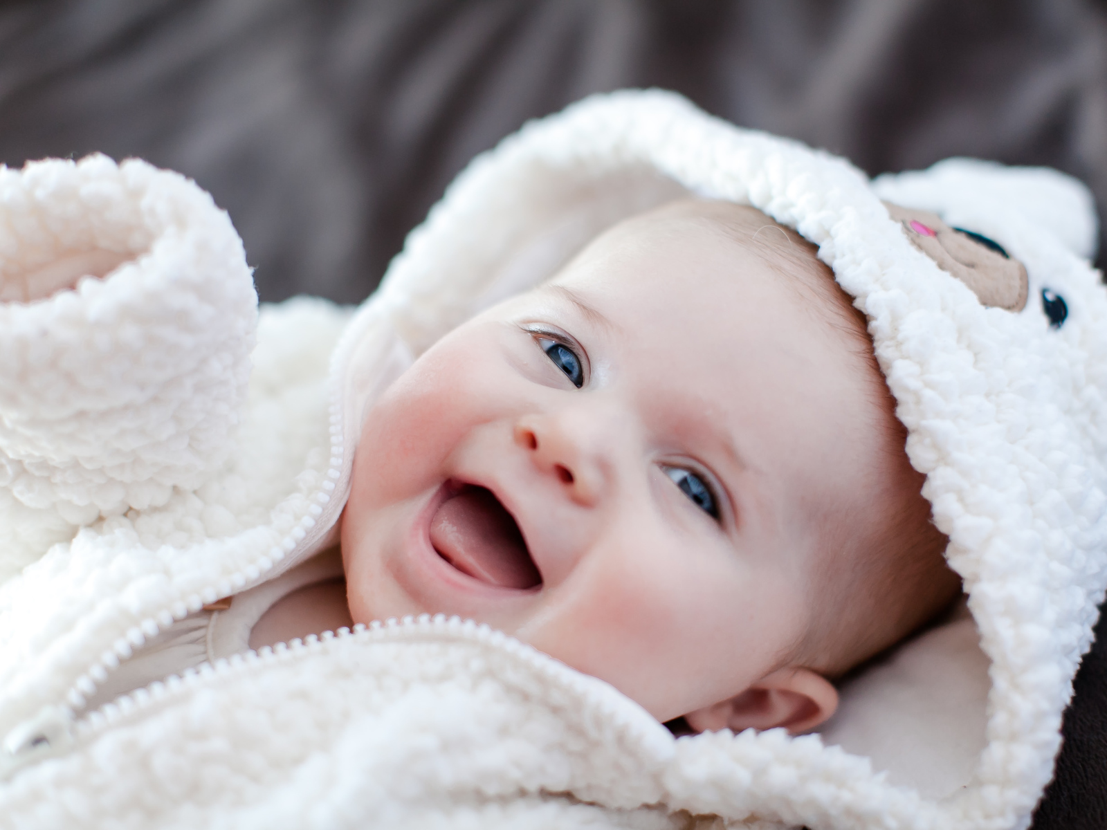 Улыбающийся милый ребенок в теплом костюме 