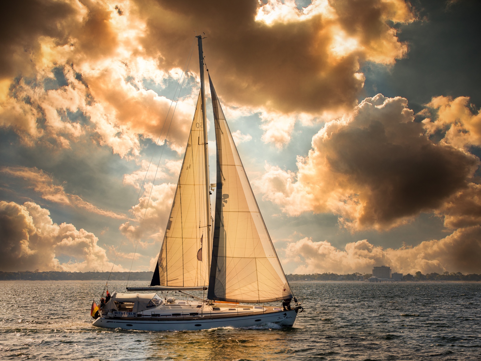 Большая парусная яхта в море на закате 