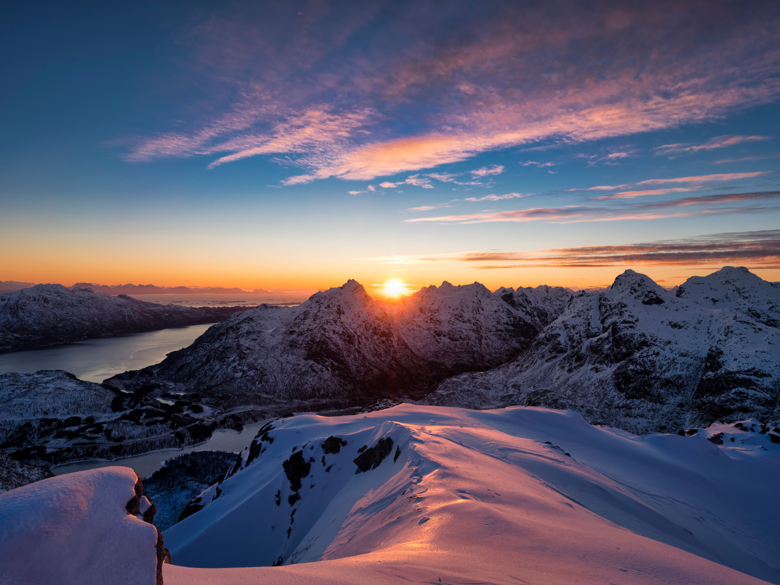 Красивый вид на заснеженные горы в лучах солнца на рассвете, Норвегия
