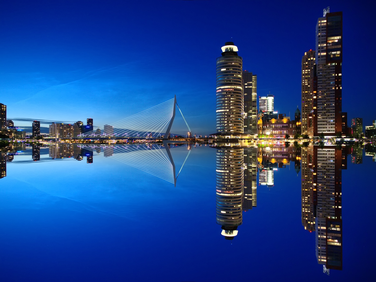 Небоскребы и мост отражаются в тихой воде