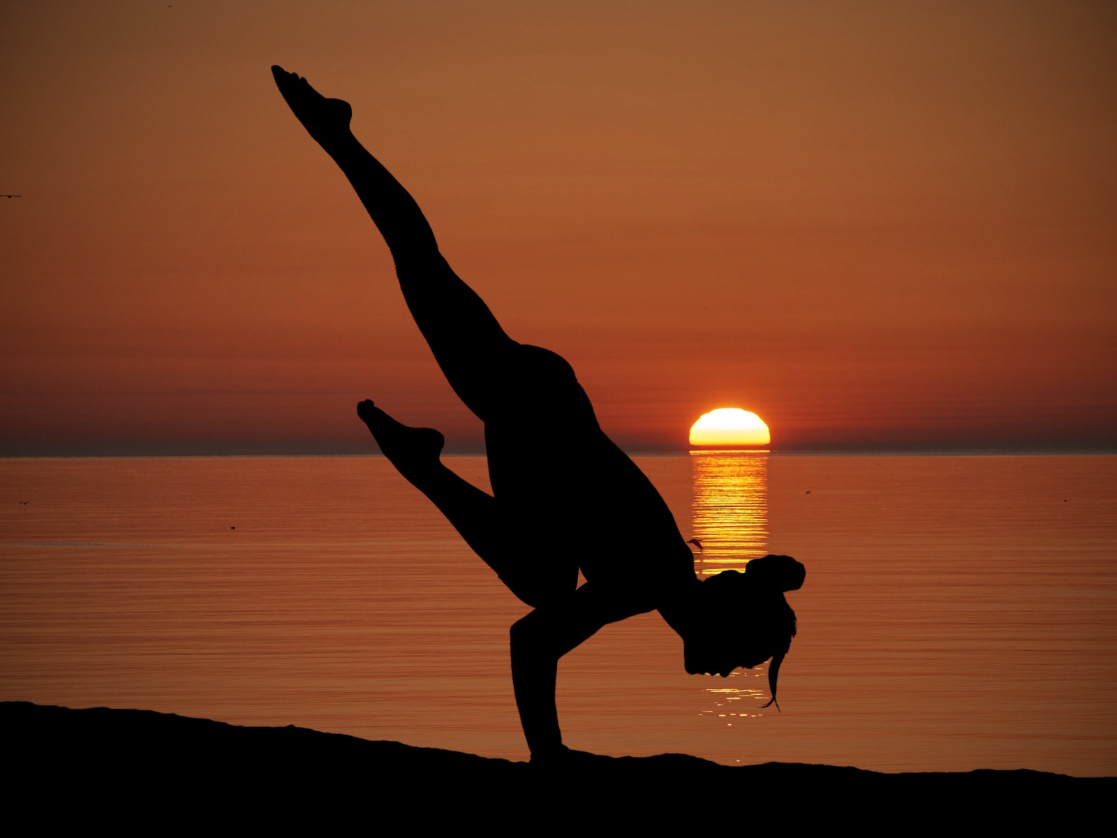 Девушка занимается йогой на закате солнца