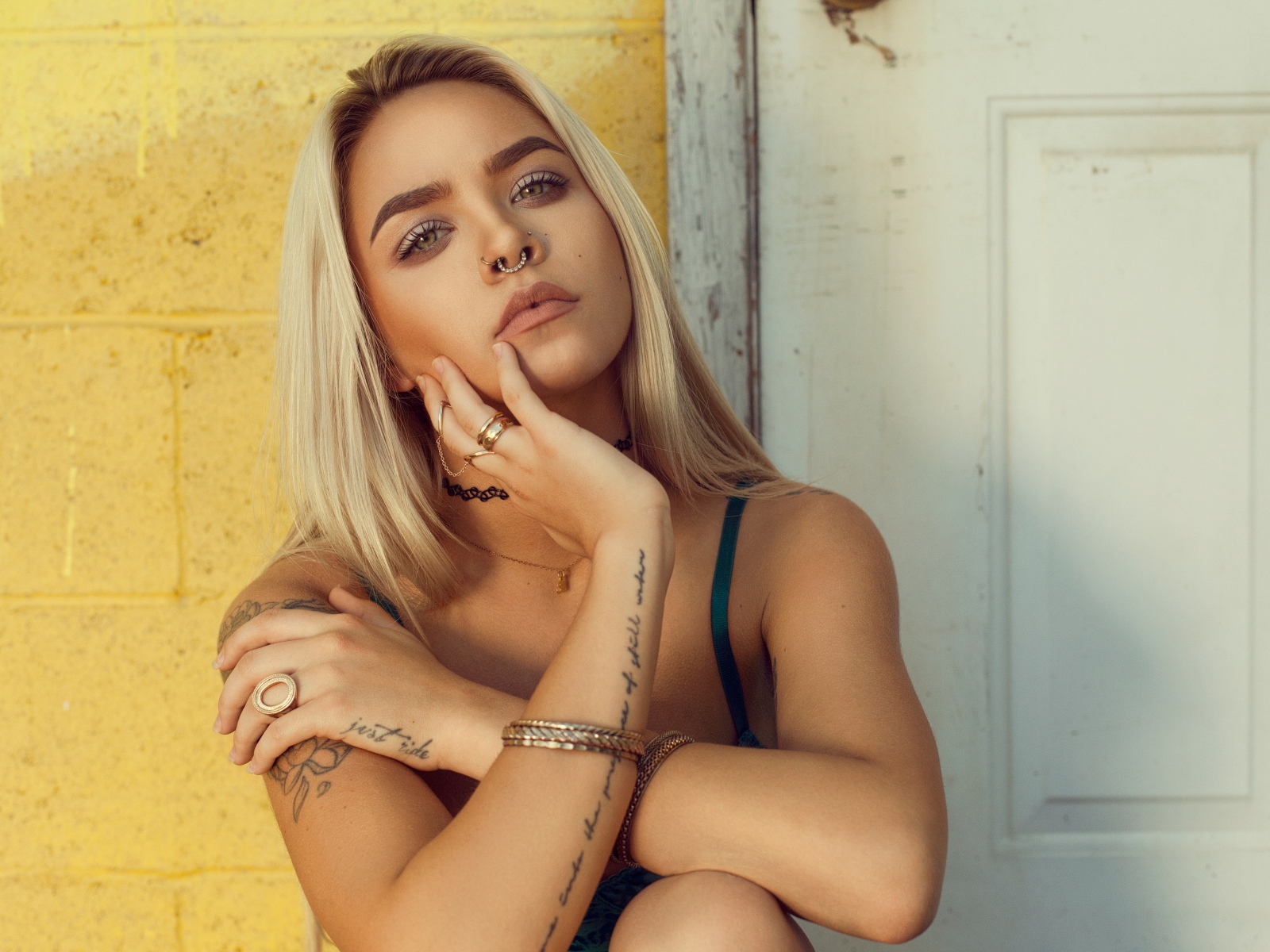 Красивая девушка в татуировках с пирсингом в носу 