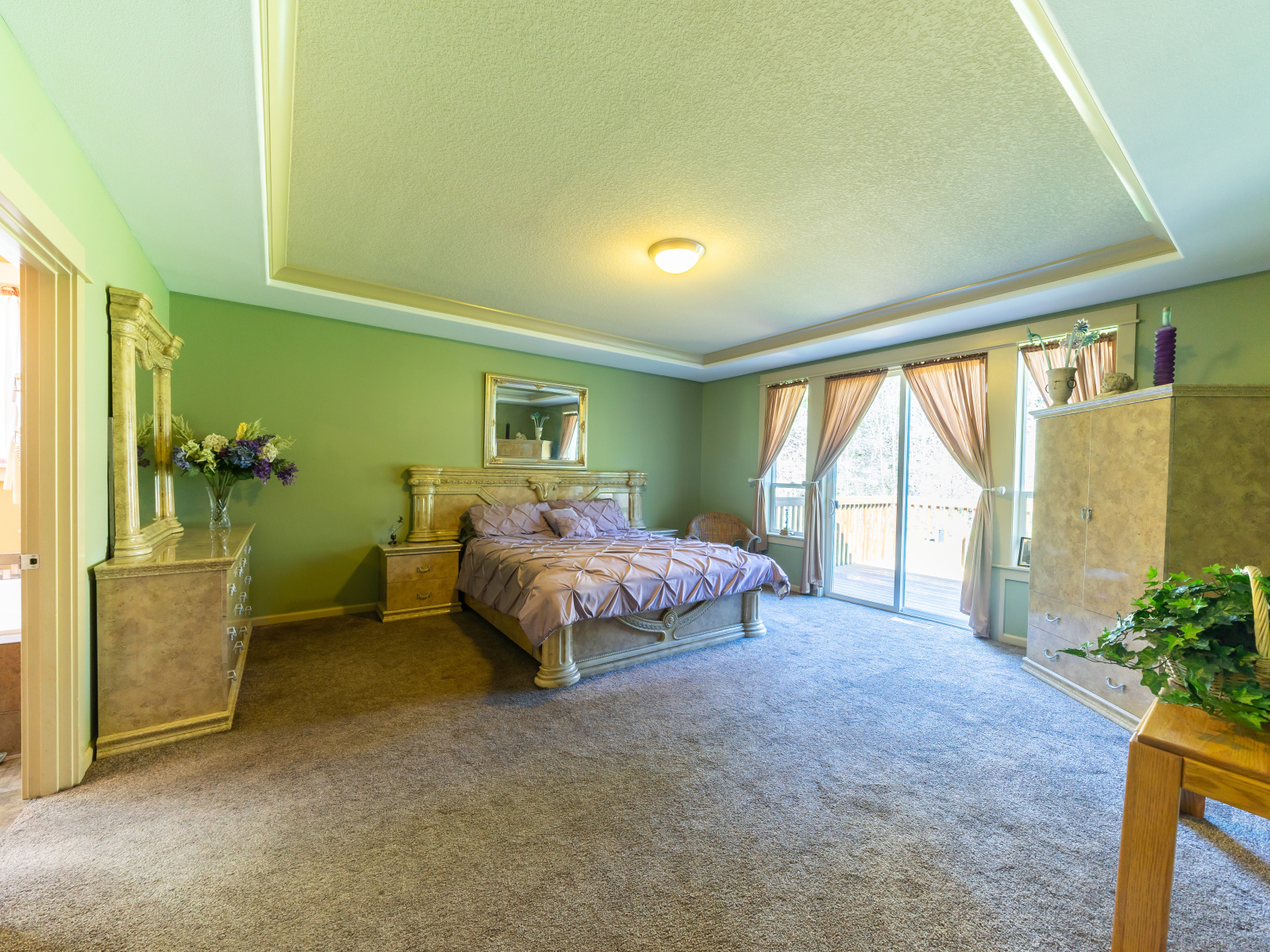 Красивая большая спальня с зелеными стенами 