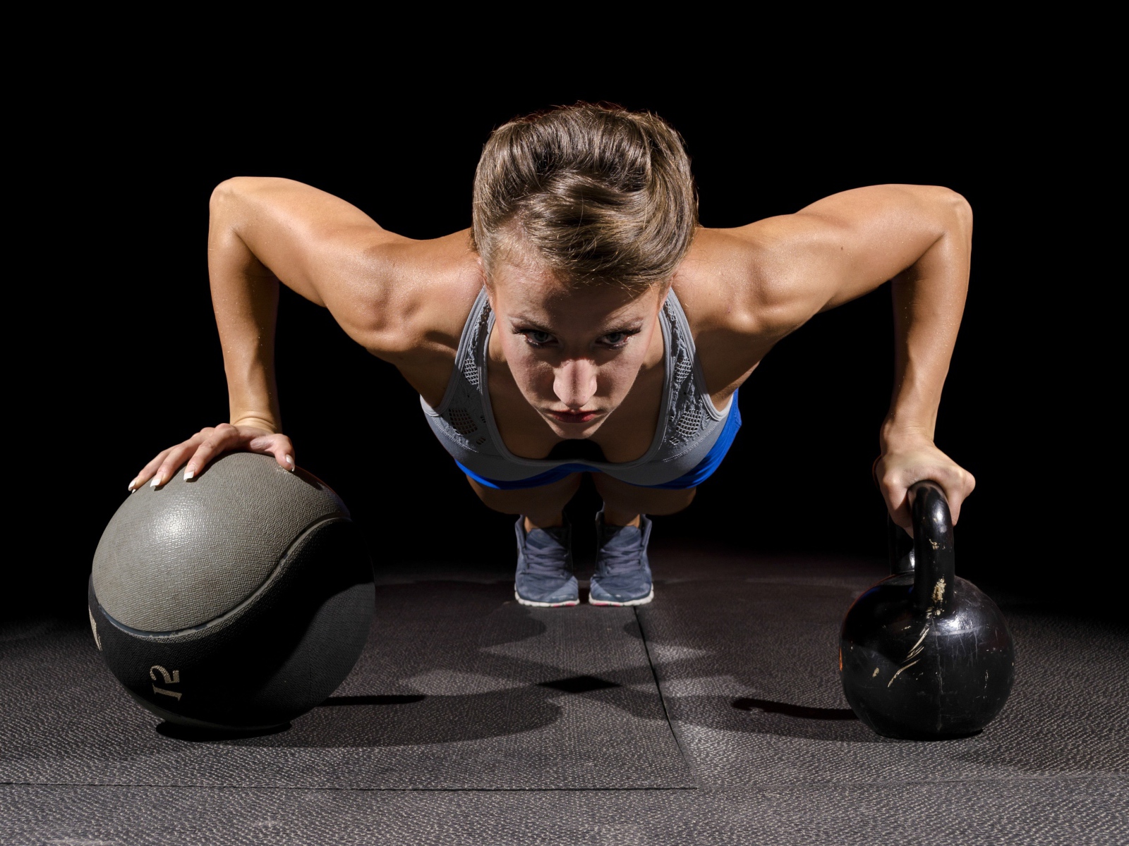 Девушка отжимается с гирями