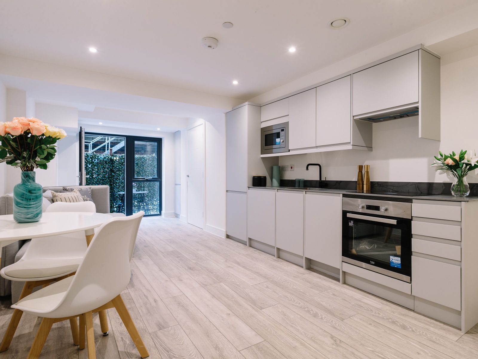 Большая просторная белая гостиная с букетом роз