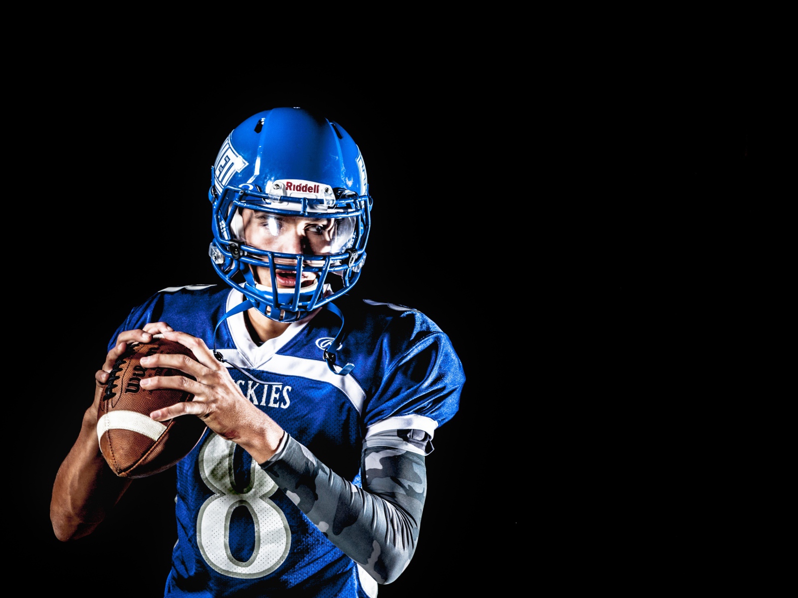 Мужчина игрок в американский футбол на черном фоне
