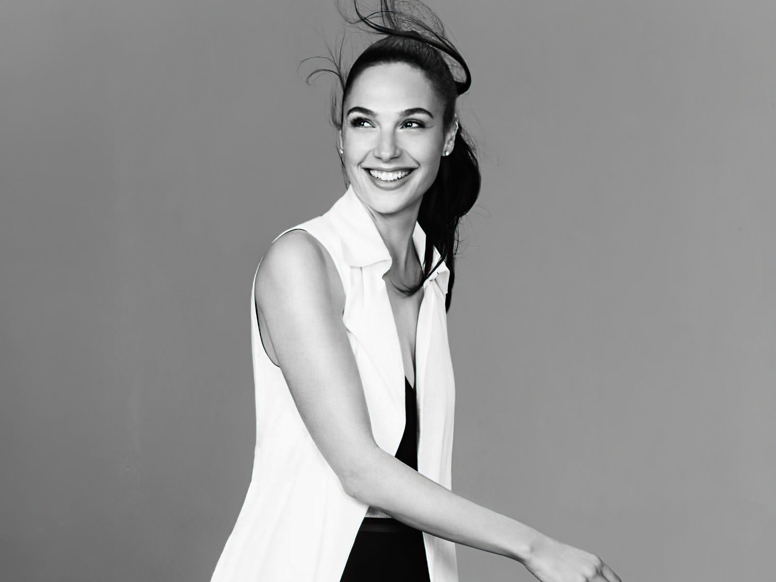 Улыбающаяся актриса Галь Гадот на сером фоне