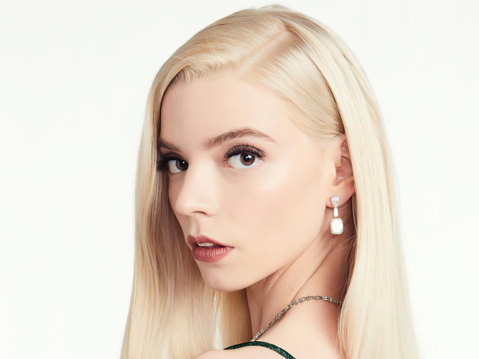 Лицо кареглазой блондинки, актрисы Аня Тейлор-Джой на белом фоне