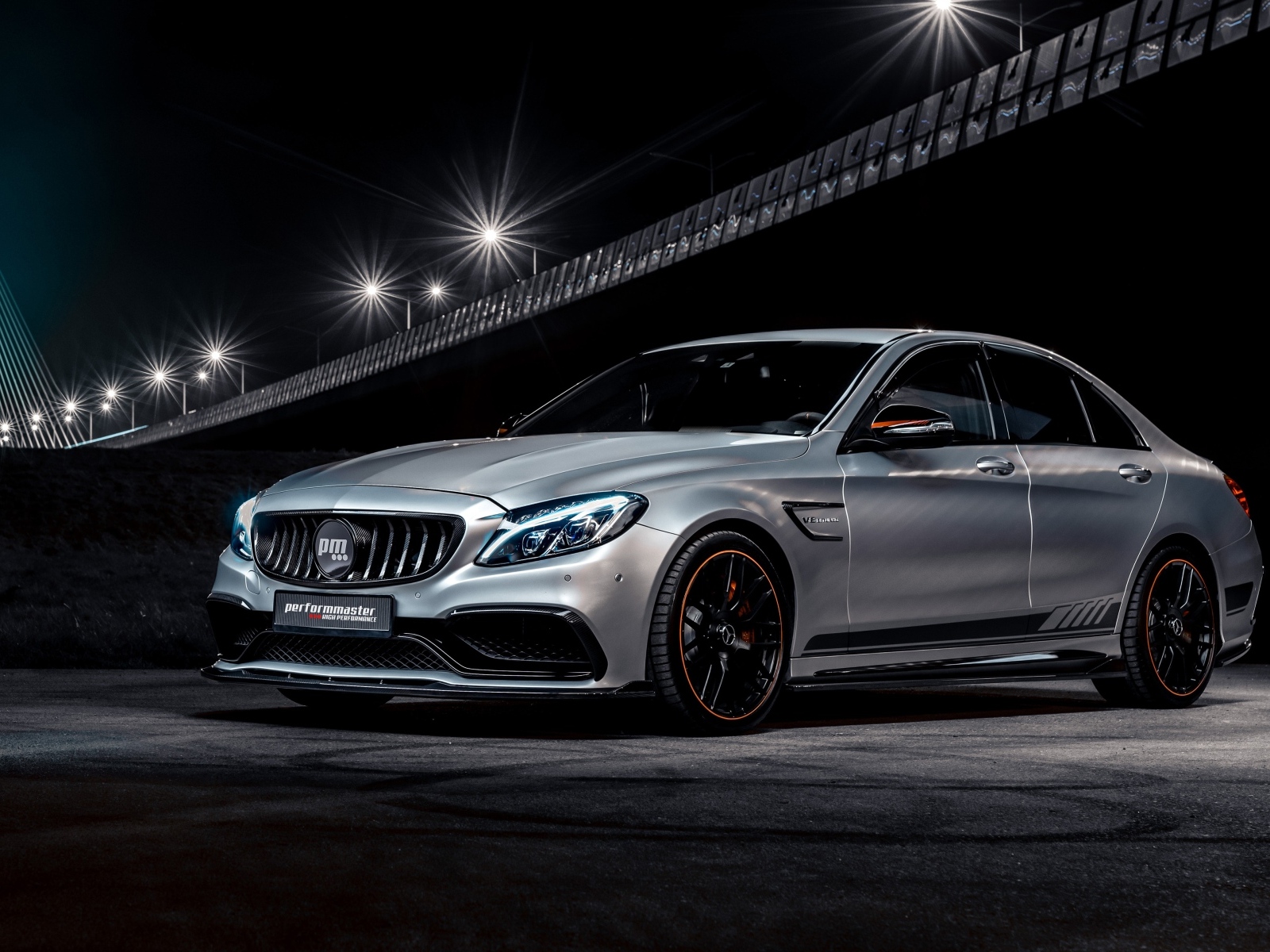 Серебристый автомобиль Performmaster C 63 V8 под мостом