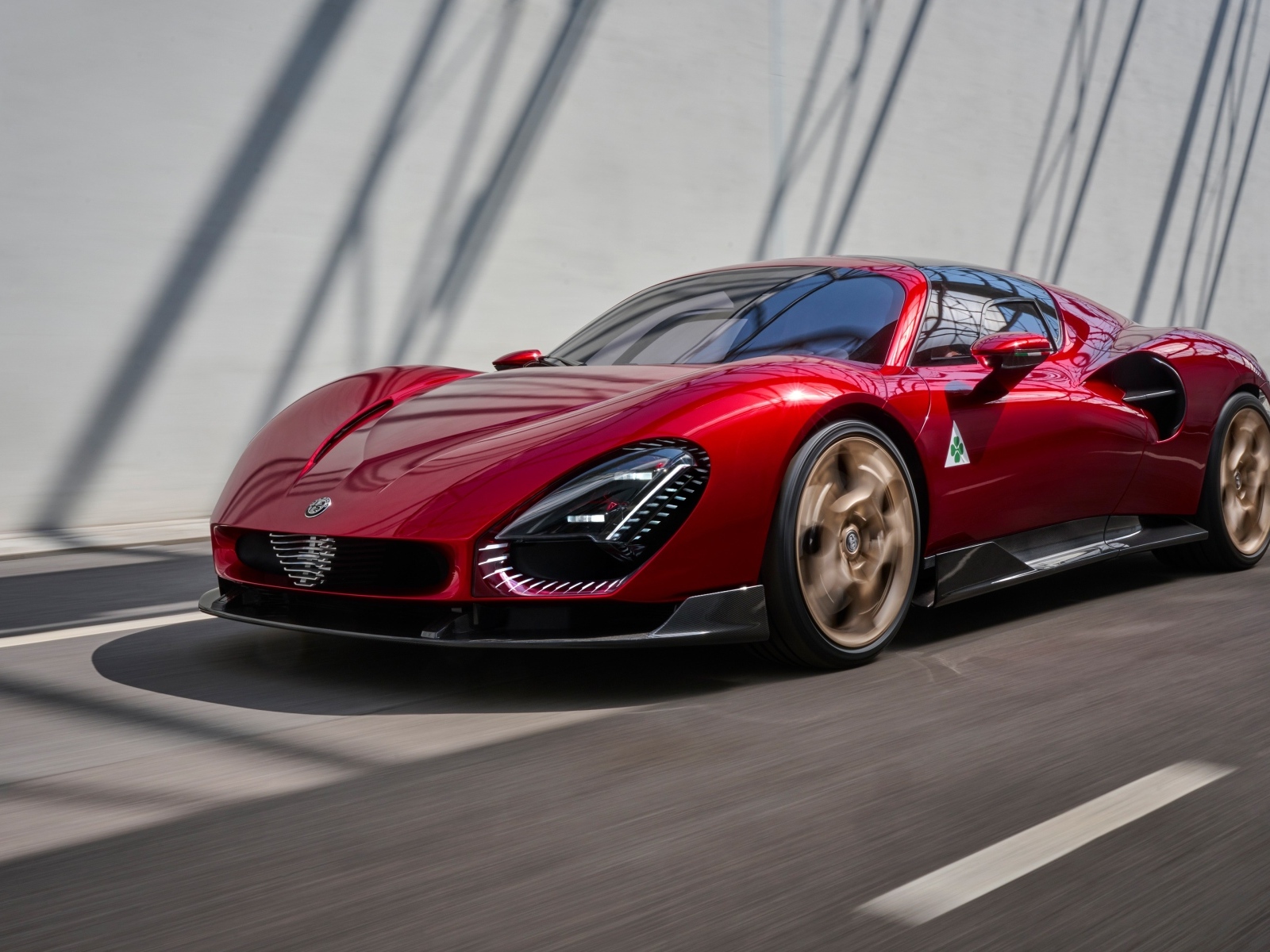 Красный  Alfa Romeo 33 Stradale 2024 года на фоне серой стены